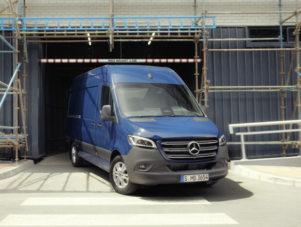Blå Mercedes-Benz Sprinter skåpbil kör ut från byggarbetsplats