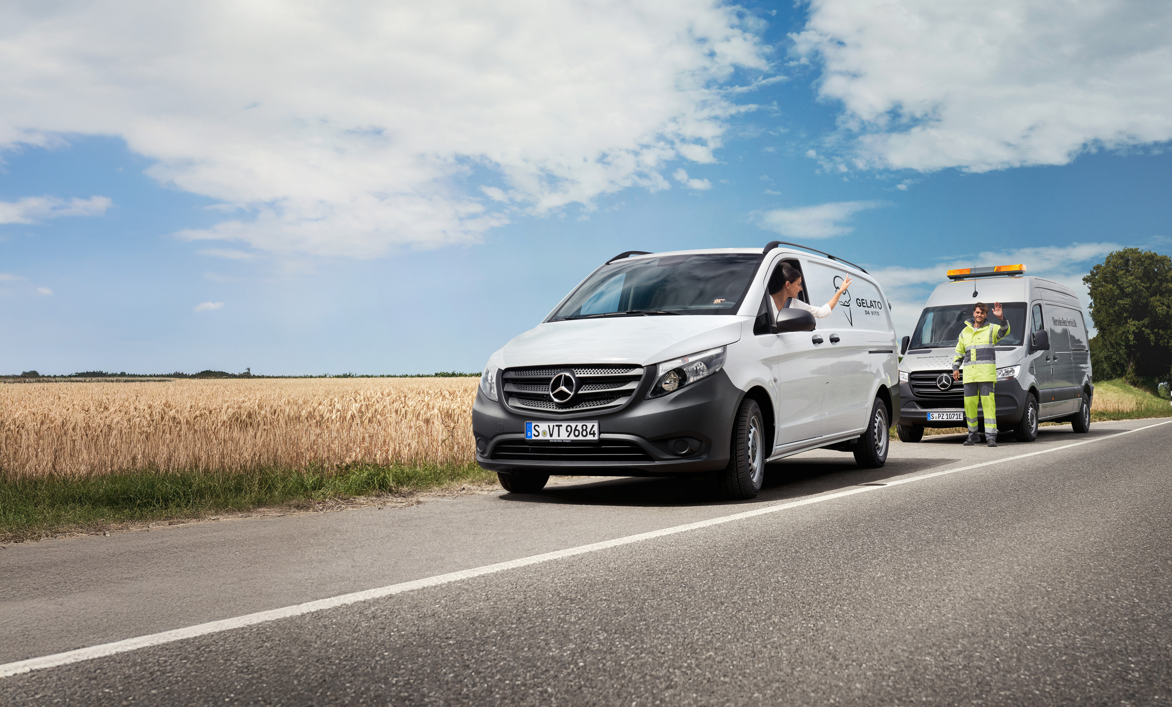 Mercedes-Benz | Vans Care | Vägassistans En person i en vit Mercedes-Benz Vito transportbil vinkar till en servicetekniker parkerad vid sidan av vägen.