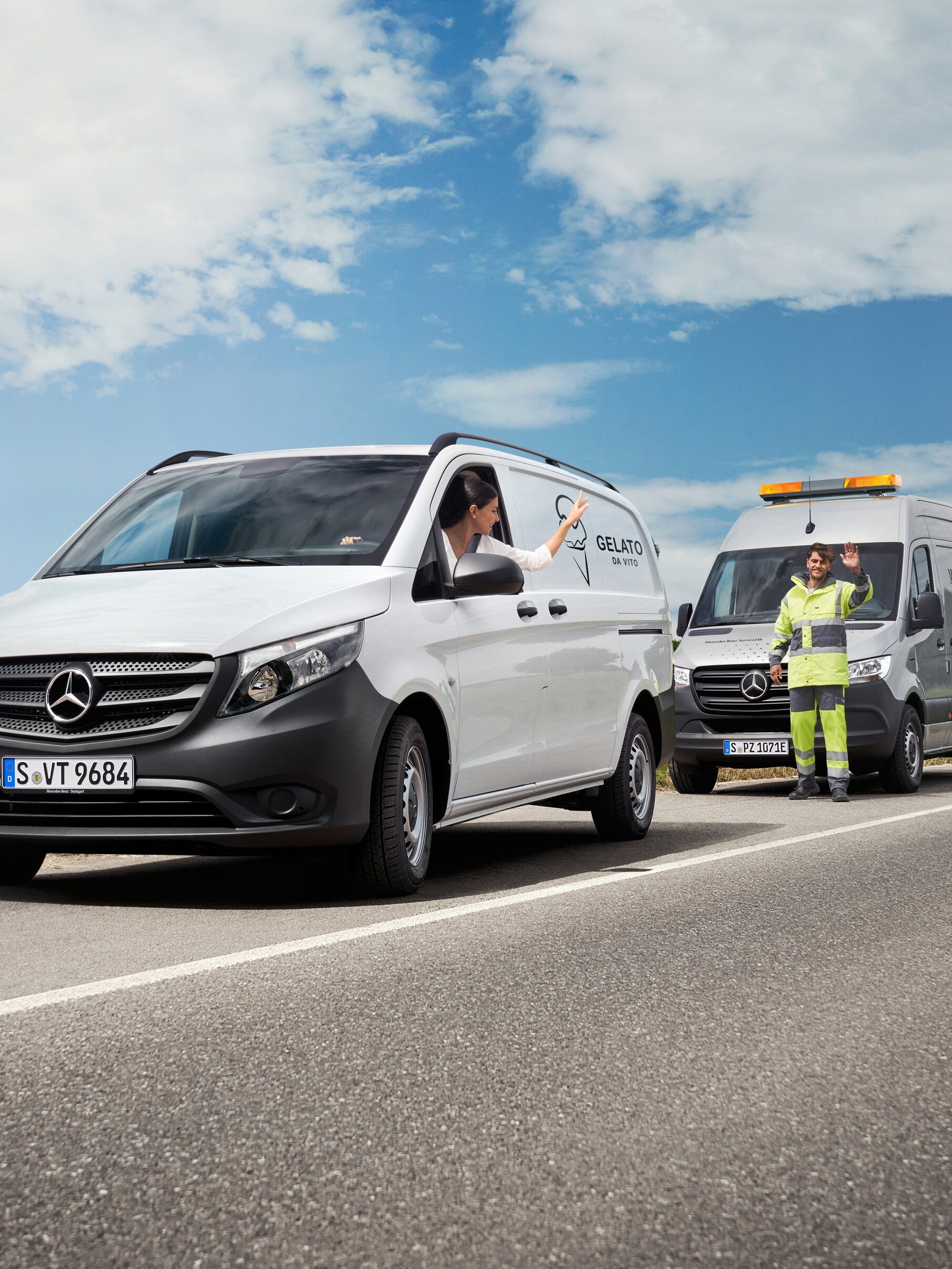 En kvinna som sitter i en vit Mercedes-Benz Vito vinkar till en servicetekniker från Mercedes-Benz som står vid sidan av vägen.