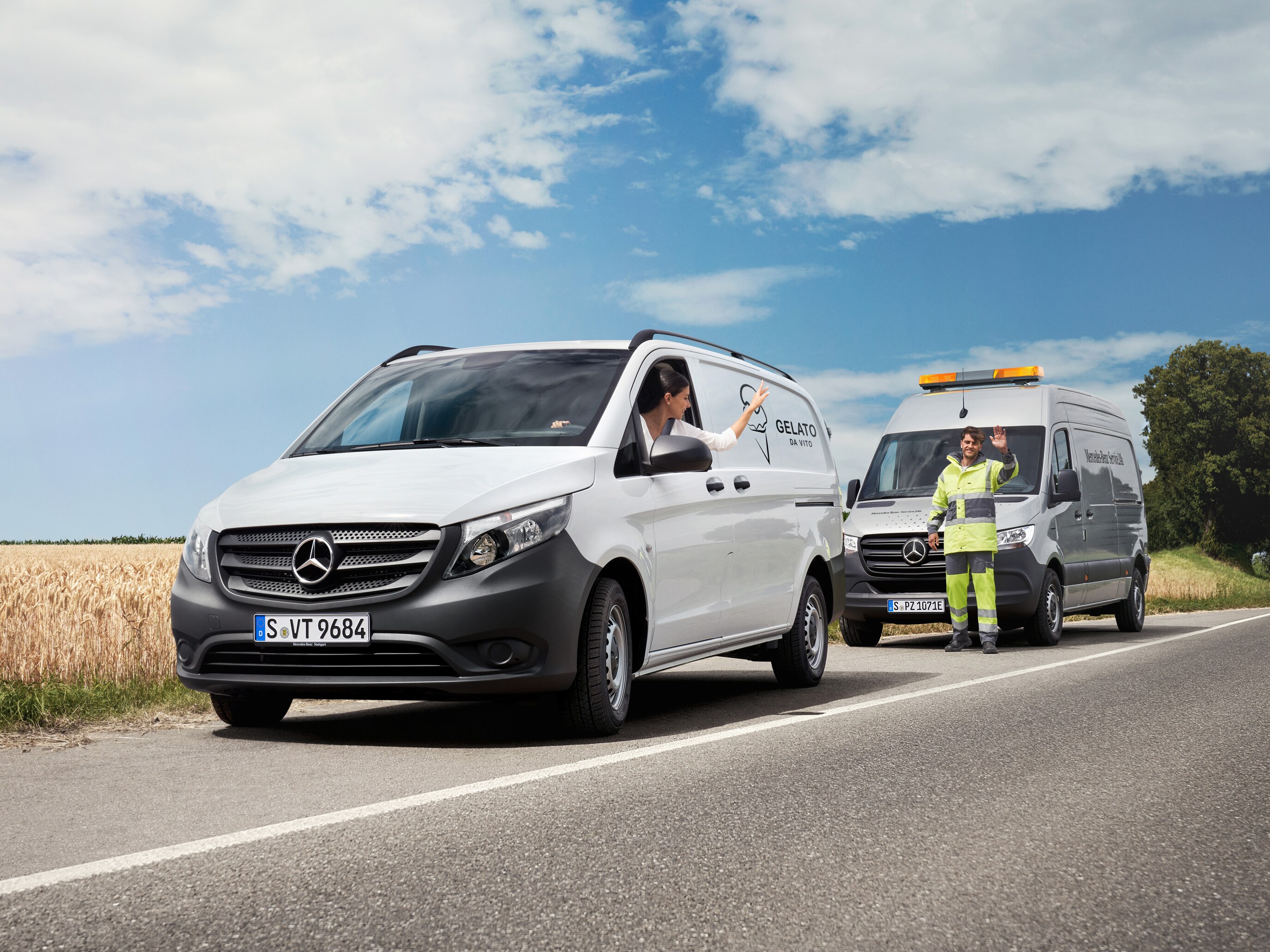 Kvinna som sitter i en vit Mercedes-Benz Vito vinkar till en servicetekniker.