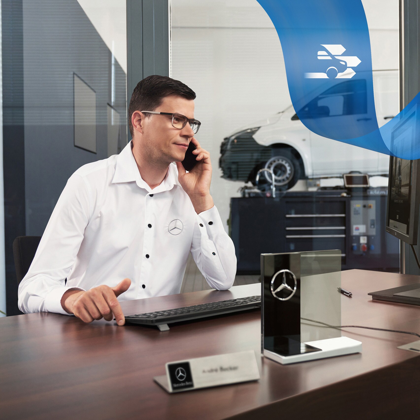 En Mercedes-Benz anställd vid ett skrivbord pratar i telefon.