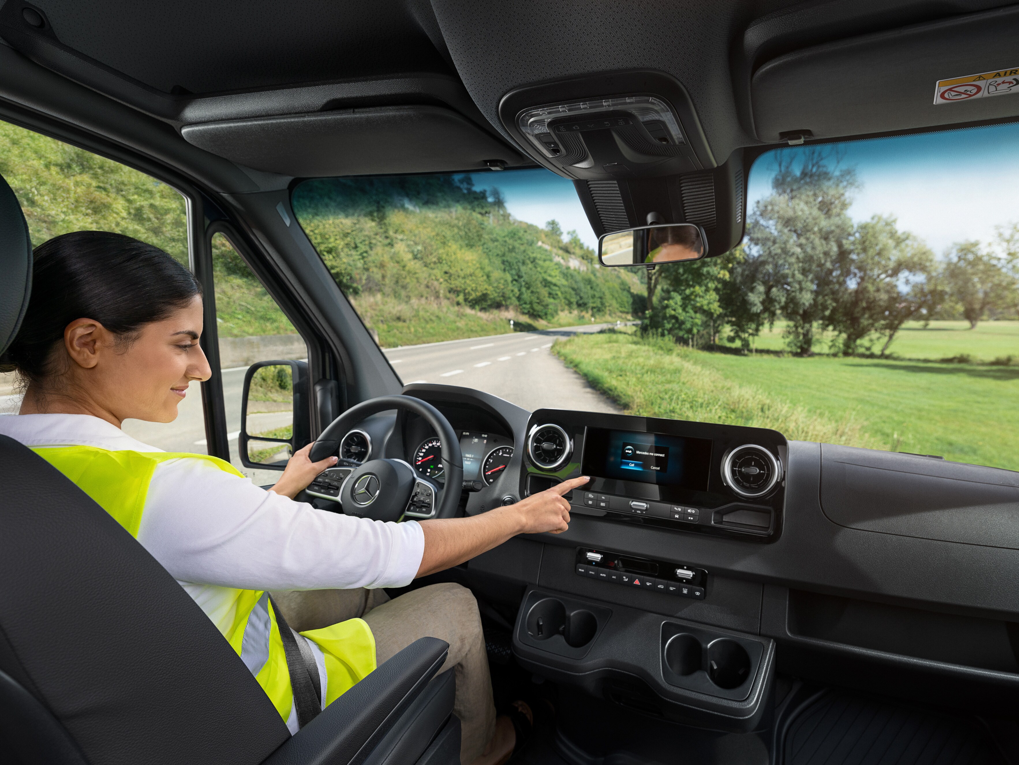 Föraren kontrollerar den inbyggda displayen i sin Mercedes-Benz transportbil.