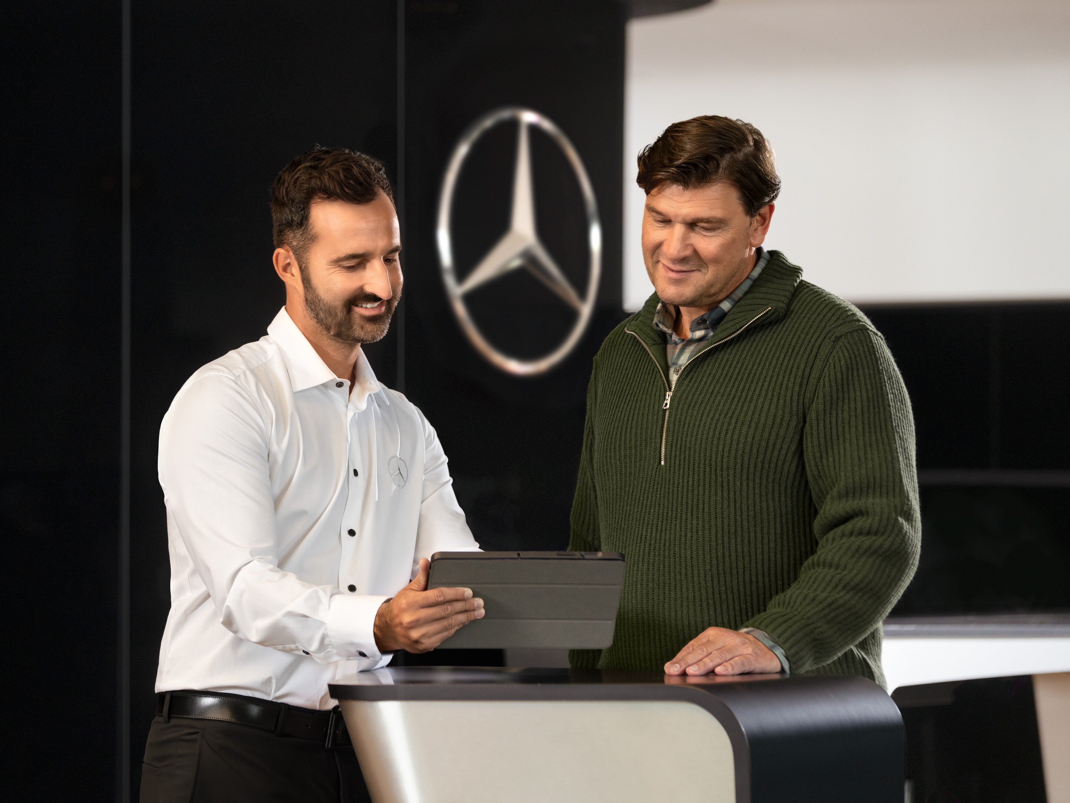 En anställd på Mercedes-Benz pratar med en kund.