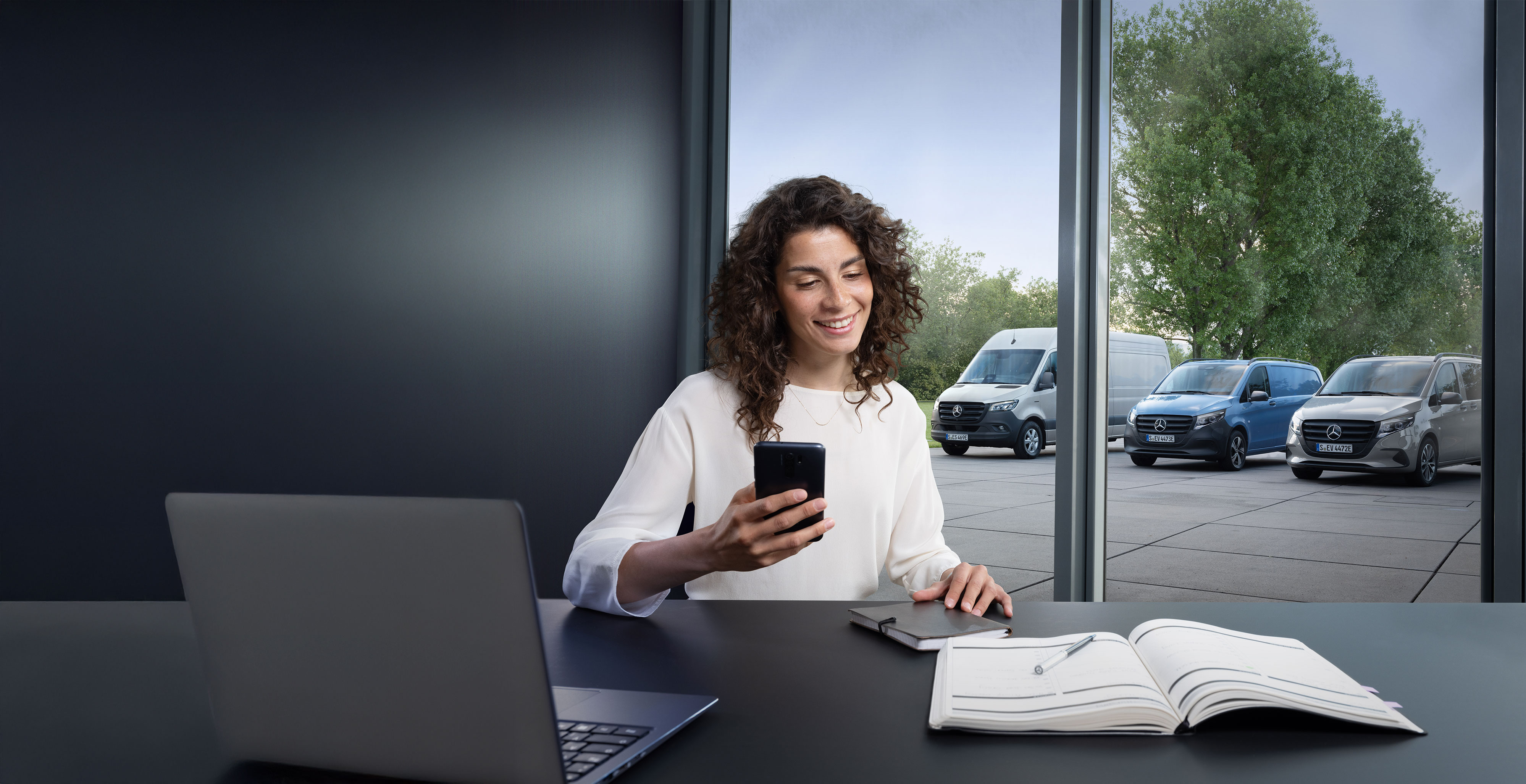 Mercedes-Benz | Bekvämlighet | Tidsbokning online En kvinna som bokar service via smartphone.