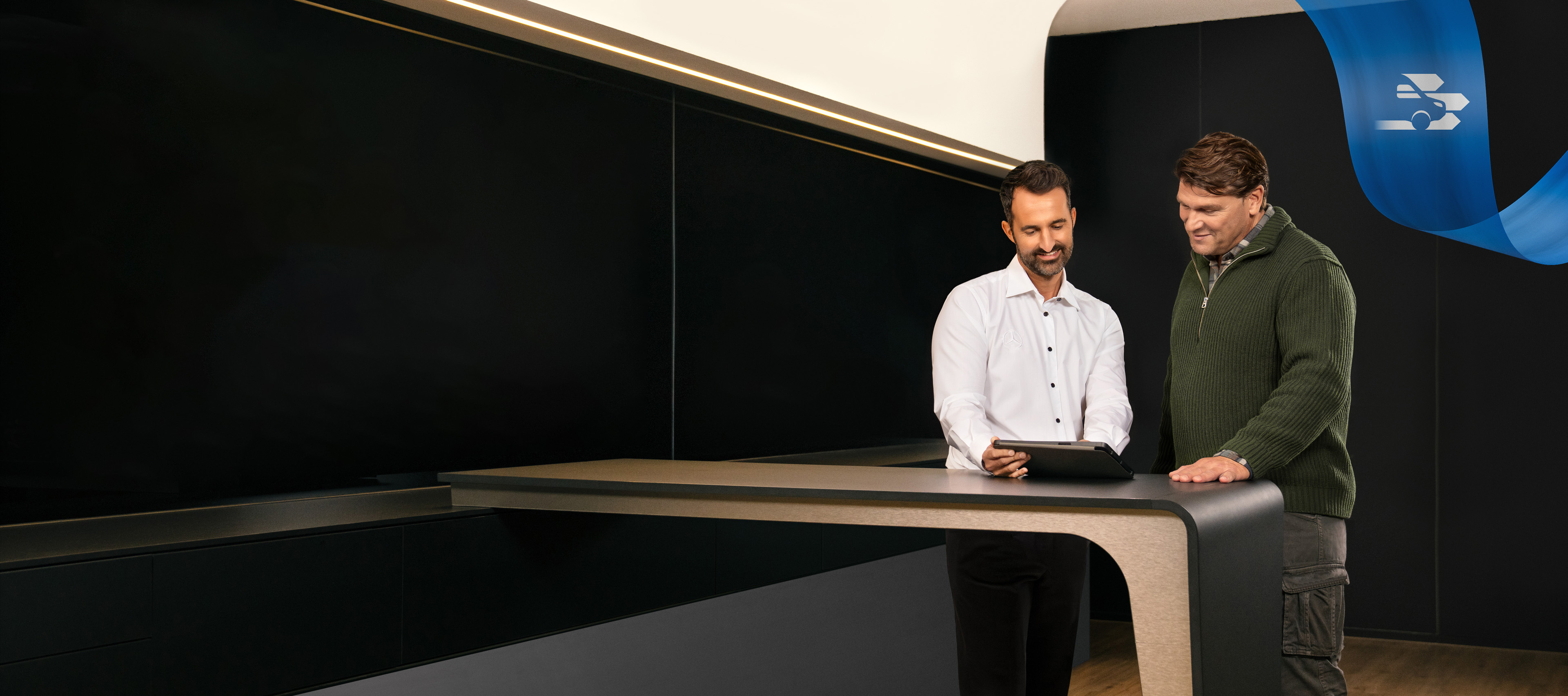 Mercedes-Benz | Bekvämlighet | Servicepartner Två män står inne på ett kontor hos en Mercedes-Benz-servicepartner.