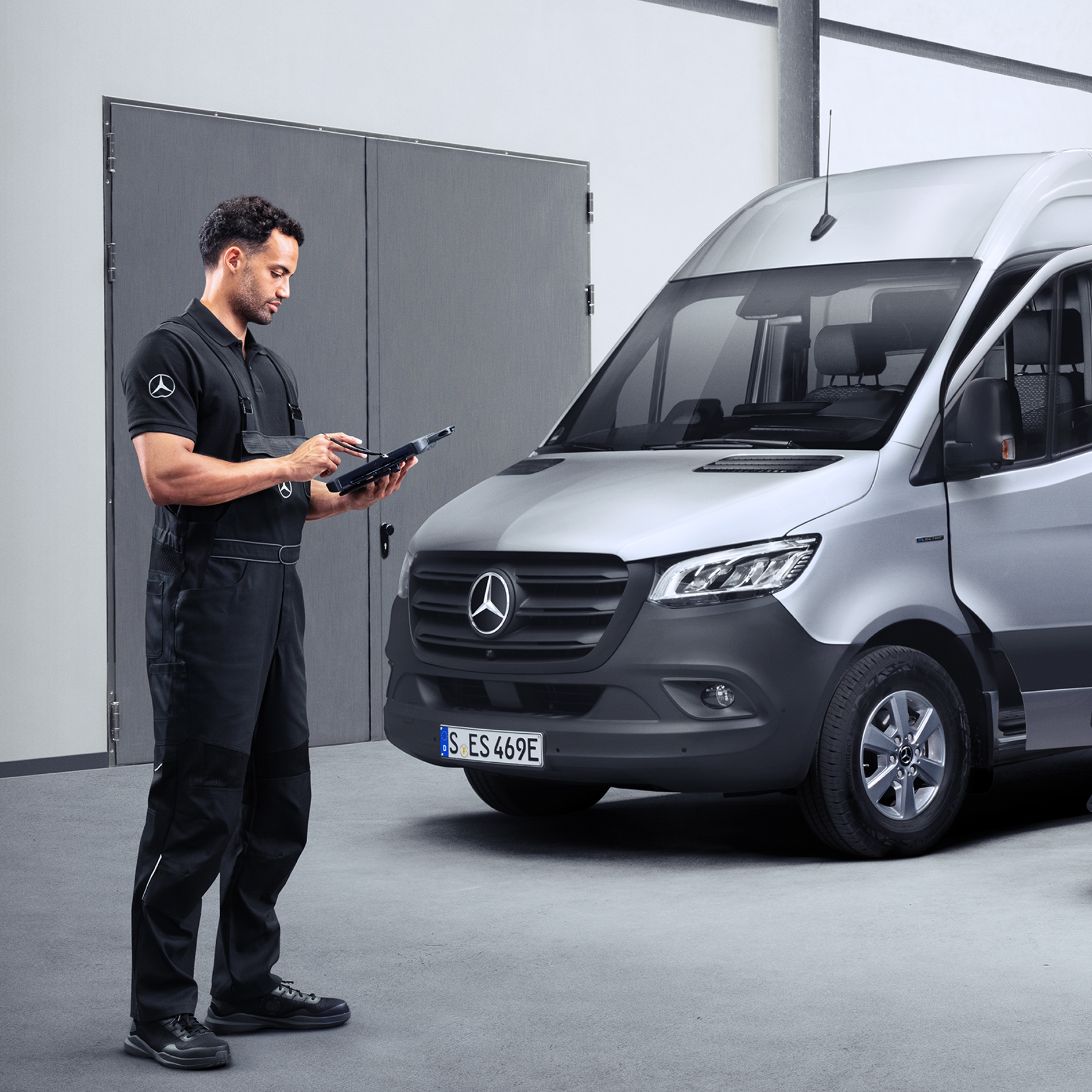 Mercedes-Benz | Transportbilar Kvalitet Garanti En tekniker som står framför en Mercedes-Benz Sprinter och arbetar med sitt diagnosverktyg