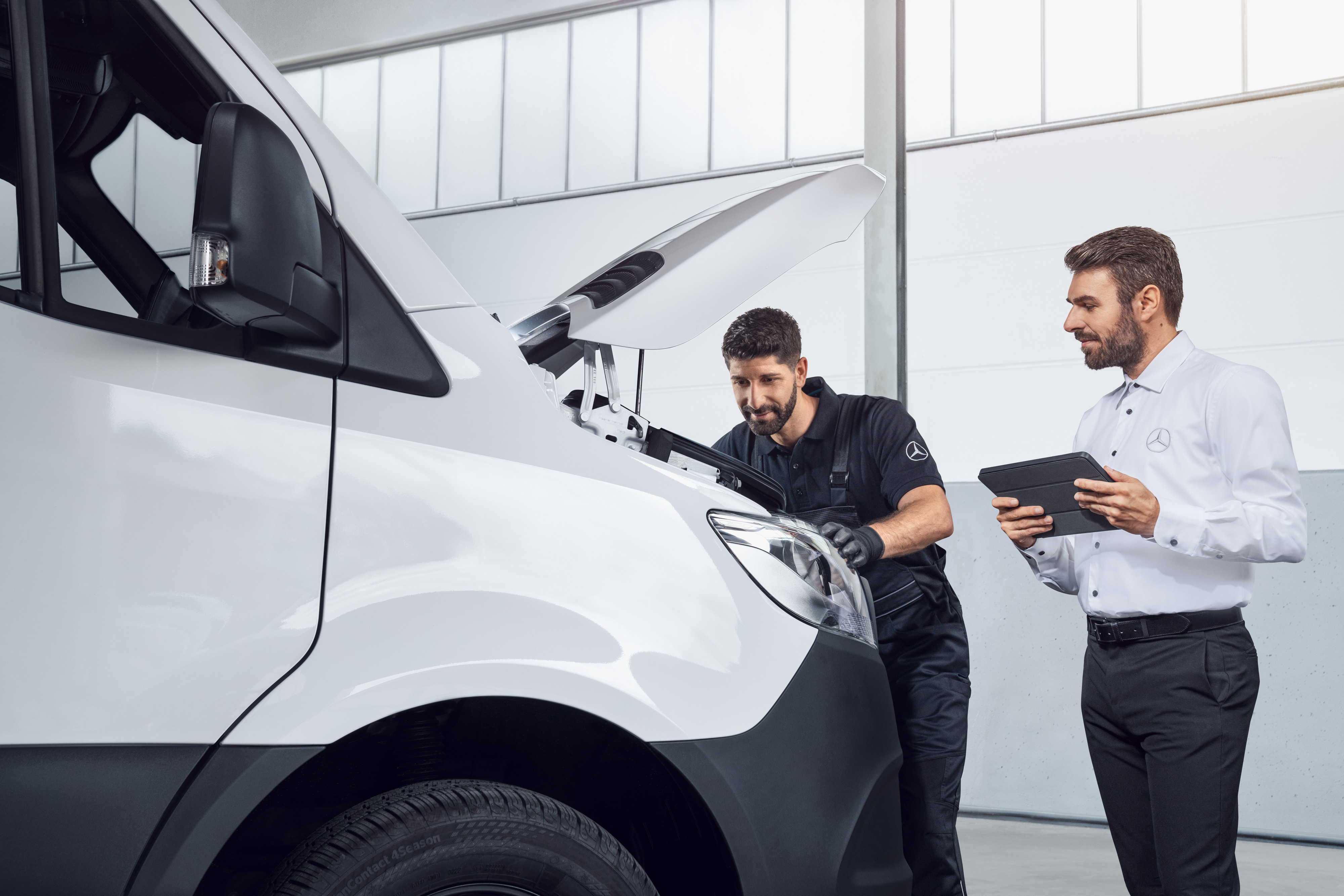 Mercedes-Benz | Transportbilar Kvalitet Originaldelar Två män testar en Mercedes Sprinter med surfplatta och öppen motorhuv, ämne: Mercedes-Benz Sprinter reservdelar.