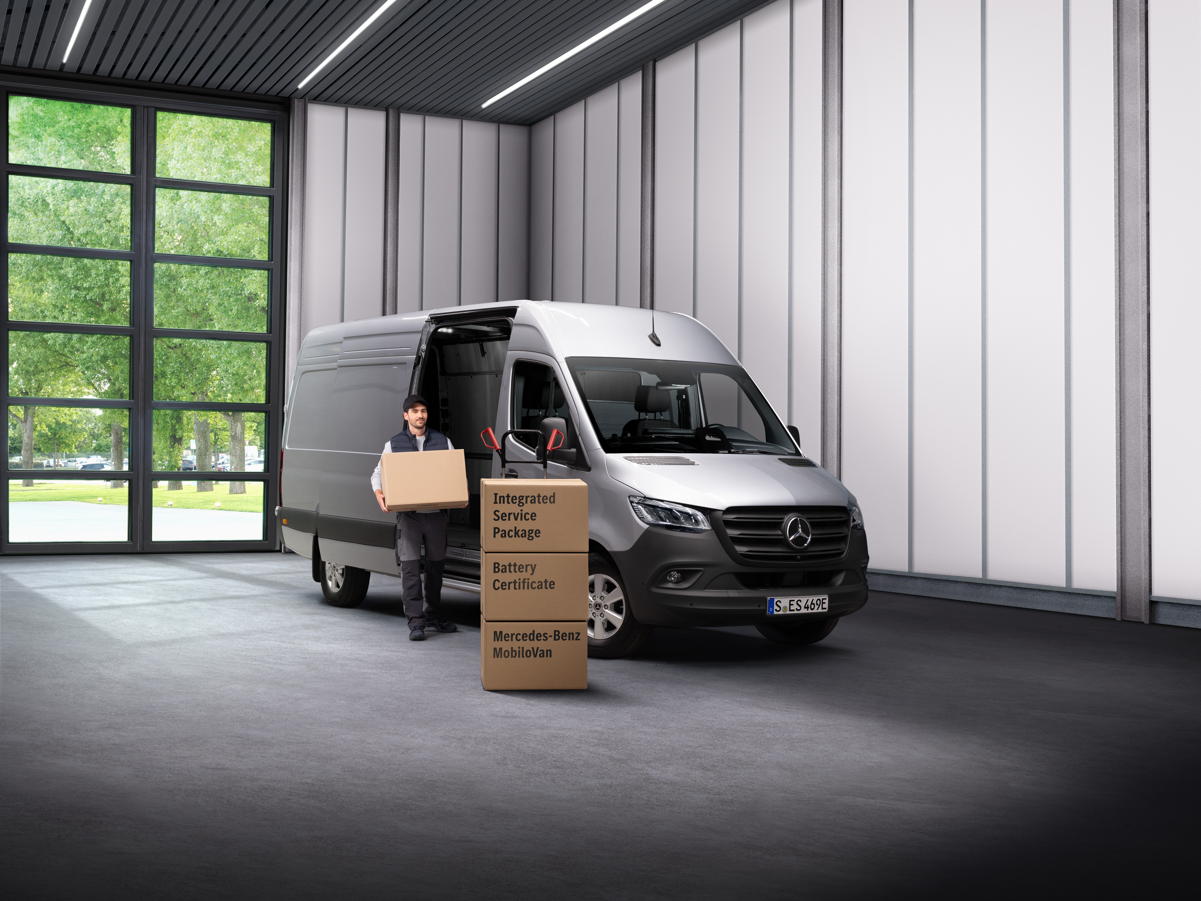 Mercedes-Benz | Service av elbilar En medarbetare på Mercedes-Benz elbilsservice bär ut lådor ur en transport.