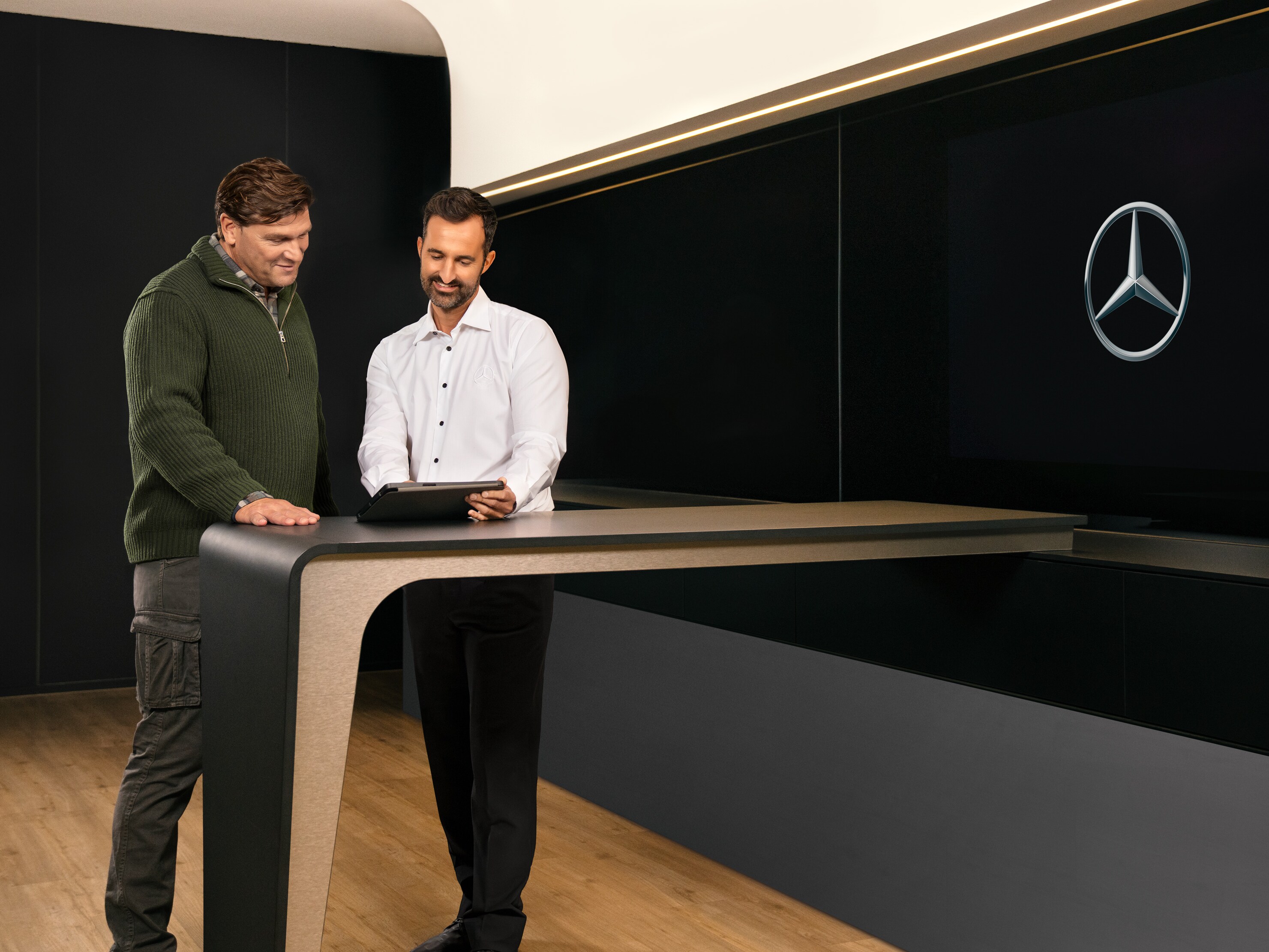 Två män diskuterar service från Mercedes-Benz.