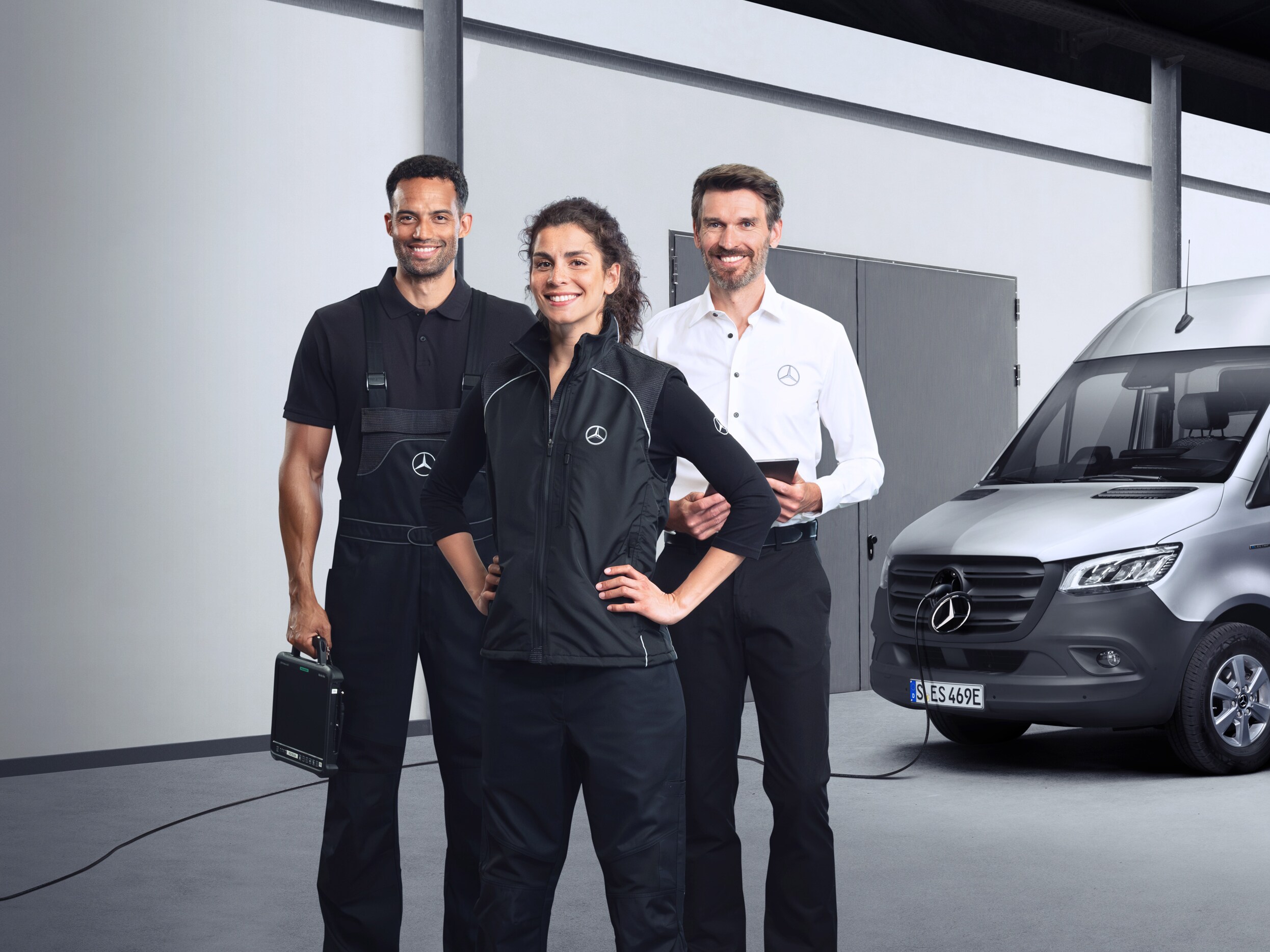 Tre medarbetare står framför en Mercedes-Benz eSprinter.