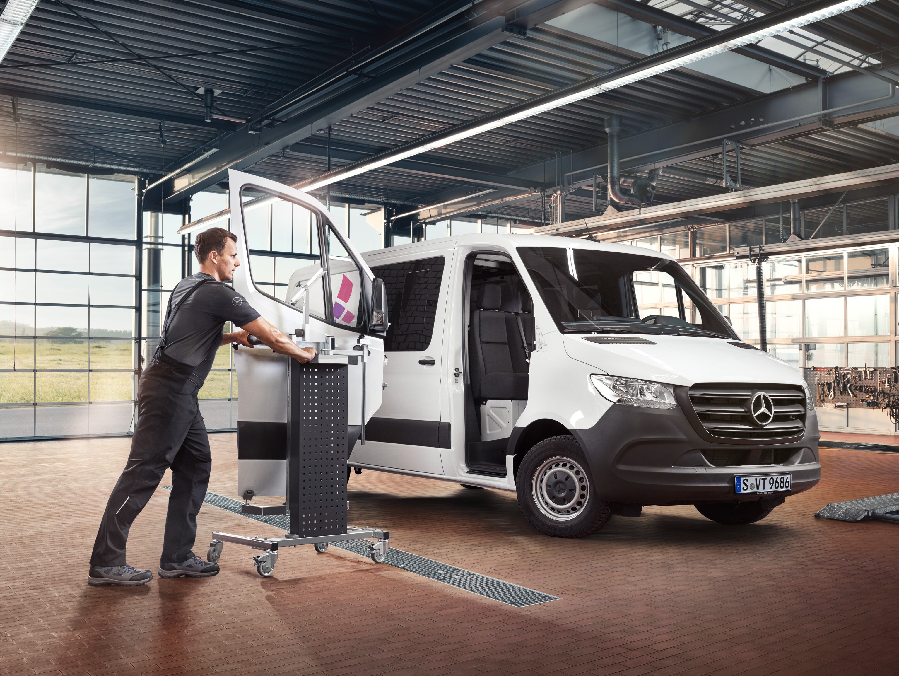 Tekniker servar passagerardörren på en vit Sprinter från Mercedes-Benz.