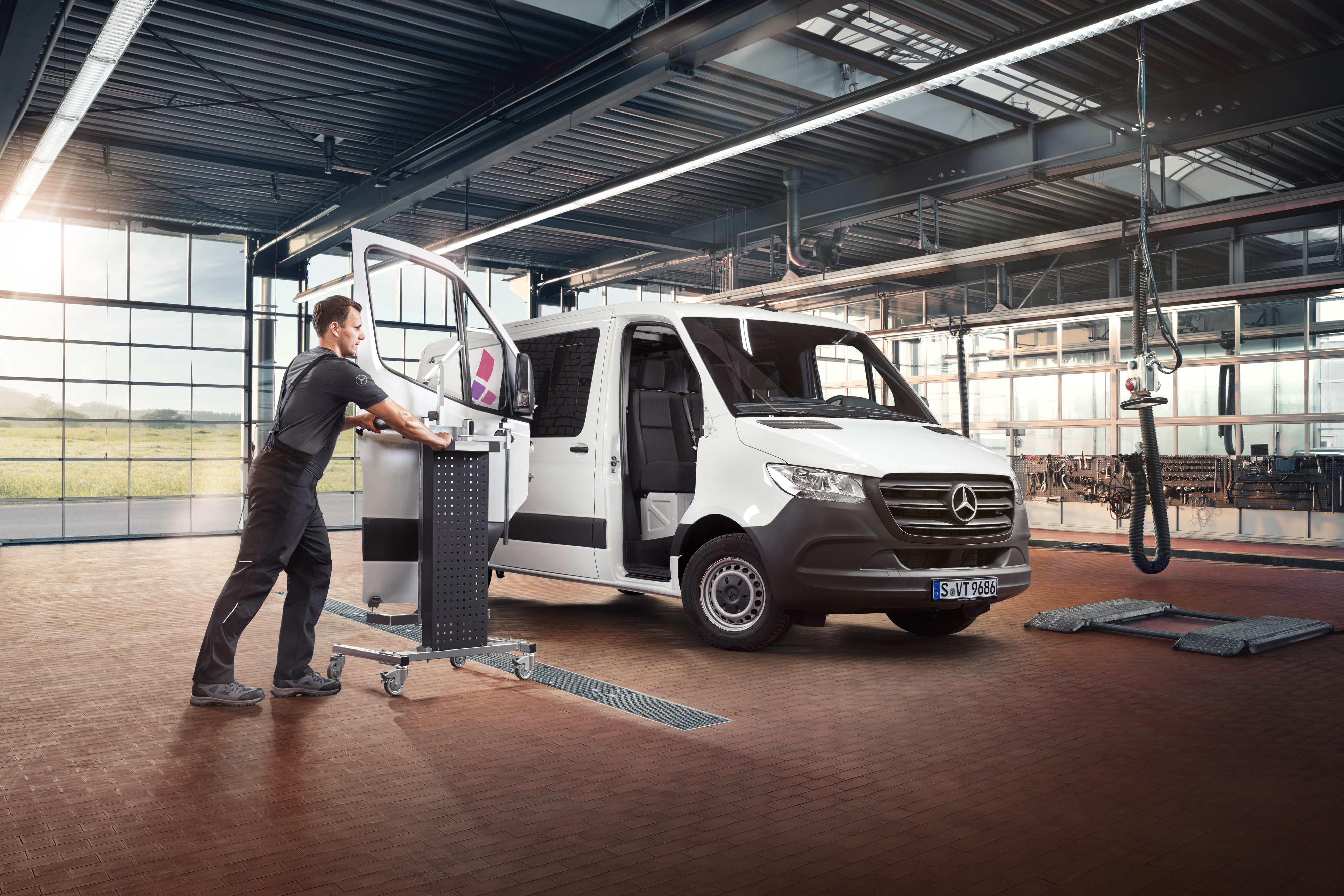 Mercedes-Benz | Översikt över tjänster | Reparation Tekniker servar passagerardörren på en vit Sprinter från Mercedes-Benz.