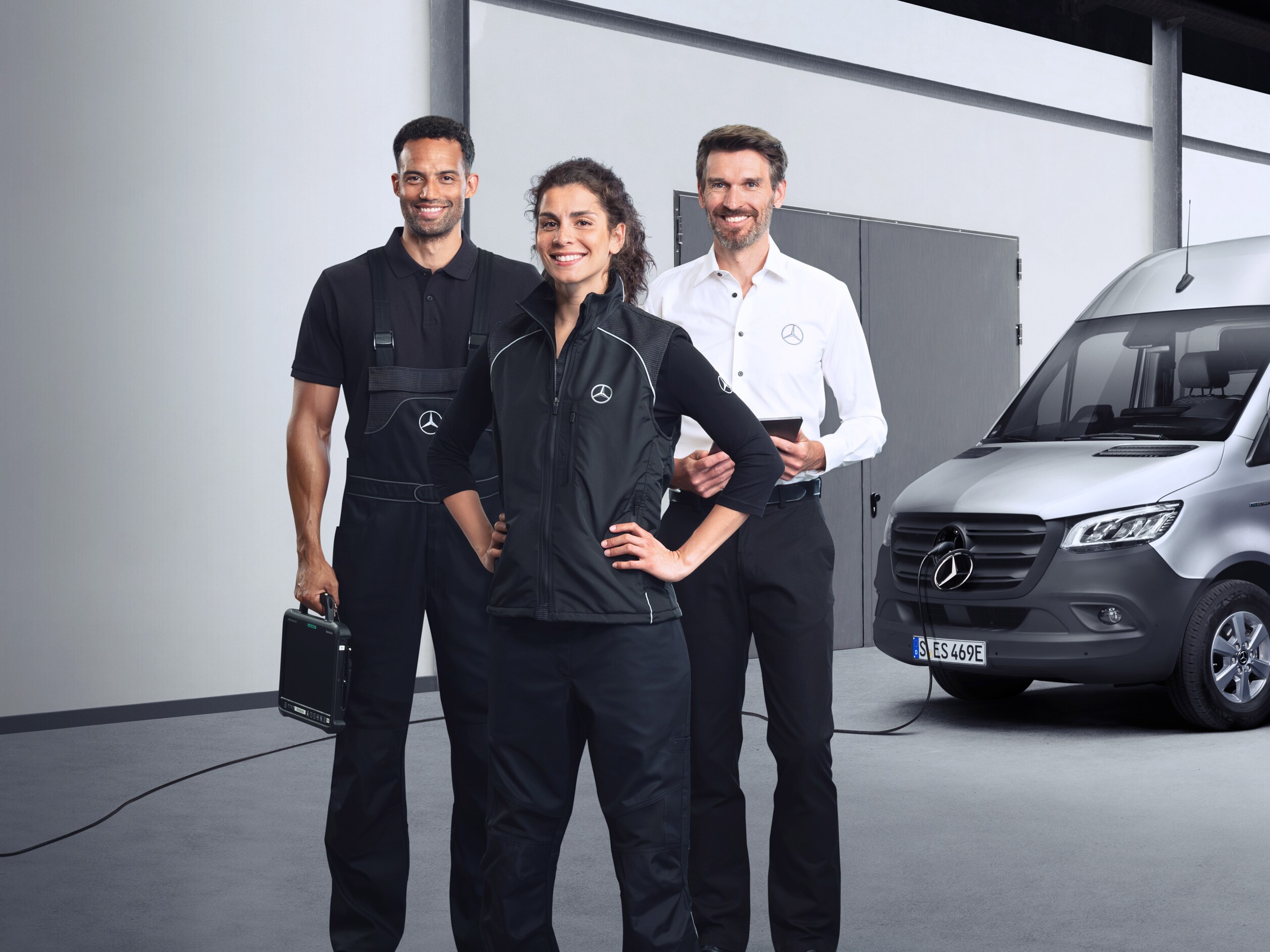 Tre medarbetare framför en eldriven Mercedes-Benz transportbil.