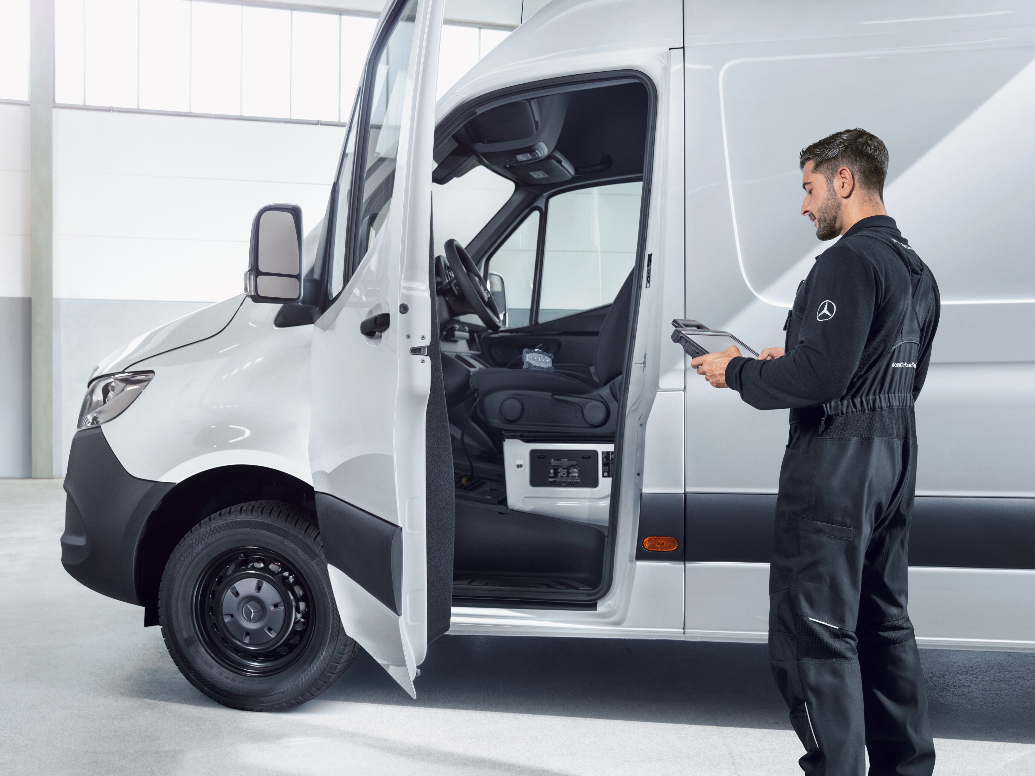 En medarbetare inspekterar en Mercedes-Benz transportbil.