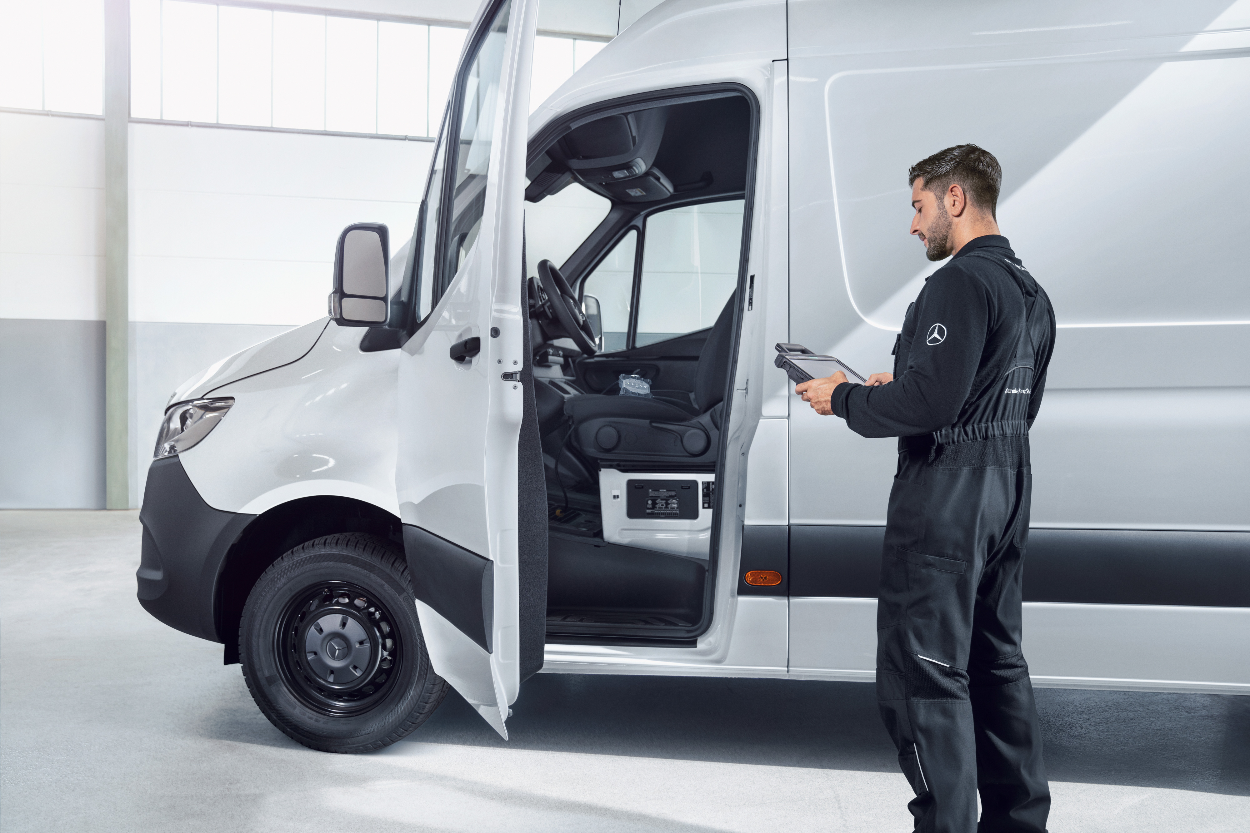Mercedes-Benz | Översikt över tjänster | Service av bilen En medarbetare inspekterar en Mercedes-Benz transportbil.
