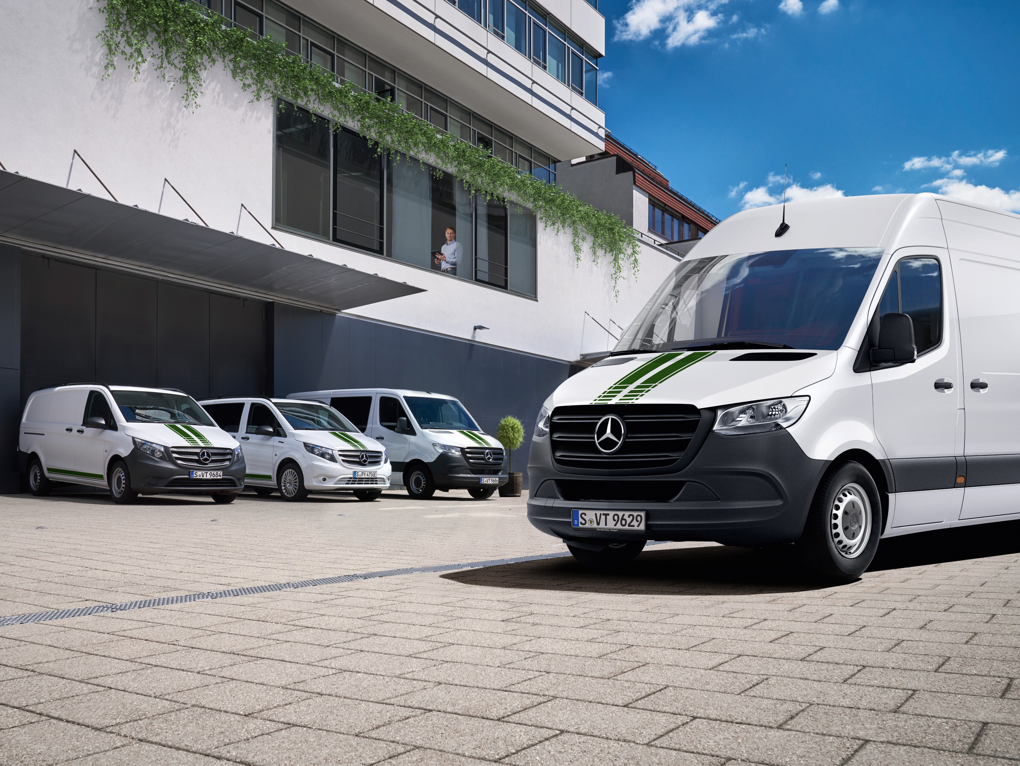 En vagnpark bestående av vita Mercedes-Benz transportbilar.