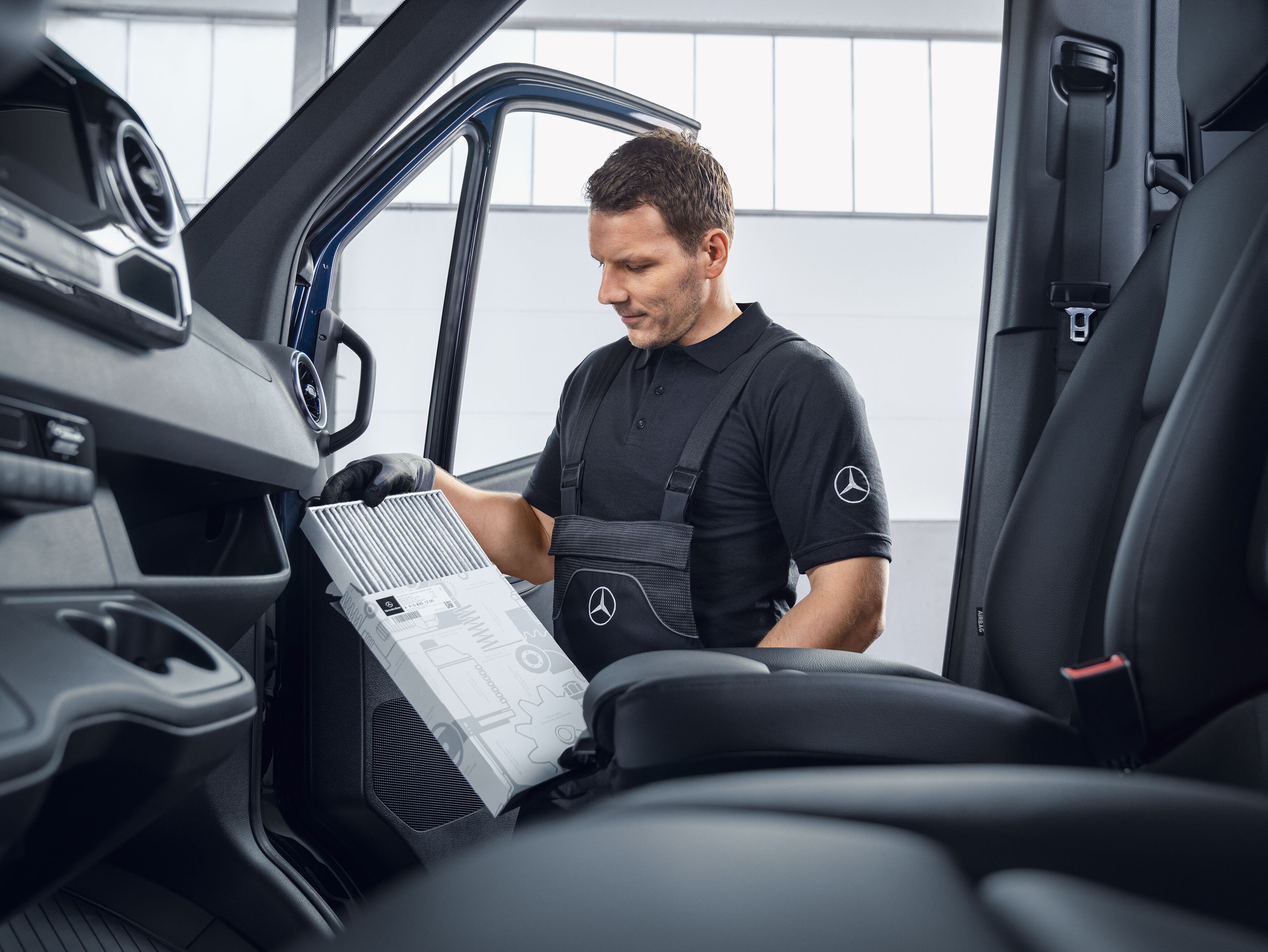 En Mercedes-Benz-mekaniker byter luftfilter.