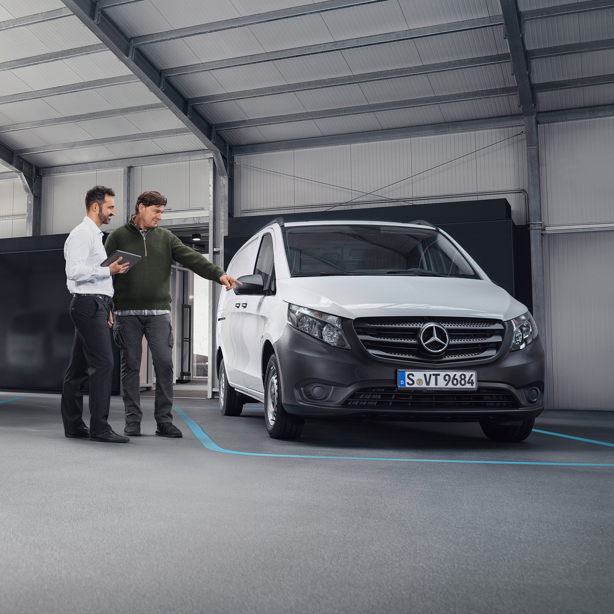 Mercedes-Benz Medarbetare med kund framför en transportbil.