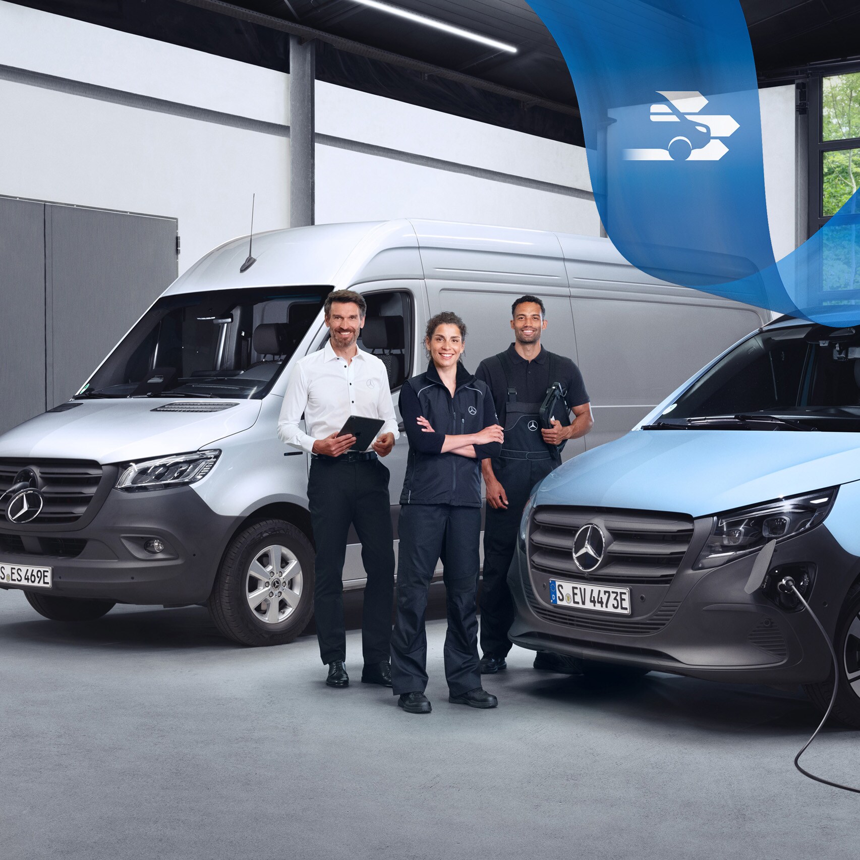 Tre Mercedes-Benz-anställda framför två elektriska transportbilar.