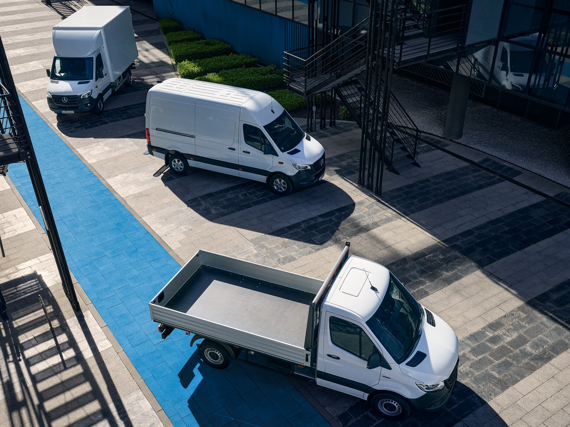 En silvrig Mercedes-Benz eSprinter parkerad vid laddstolpe