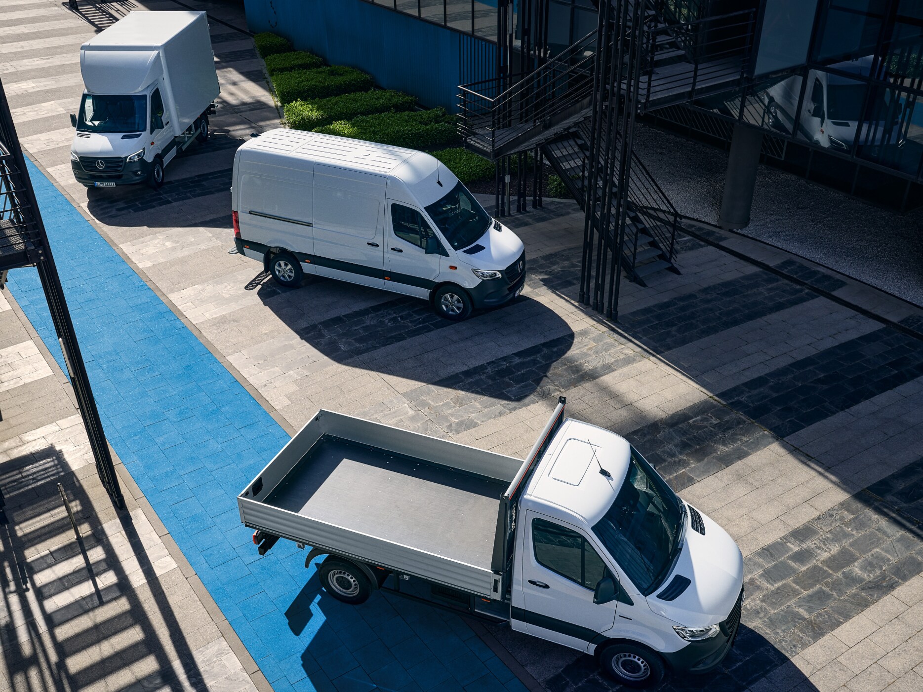 Olika elektriska transportbilar från Mercedes-Benz parkerade utanför showroom.