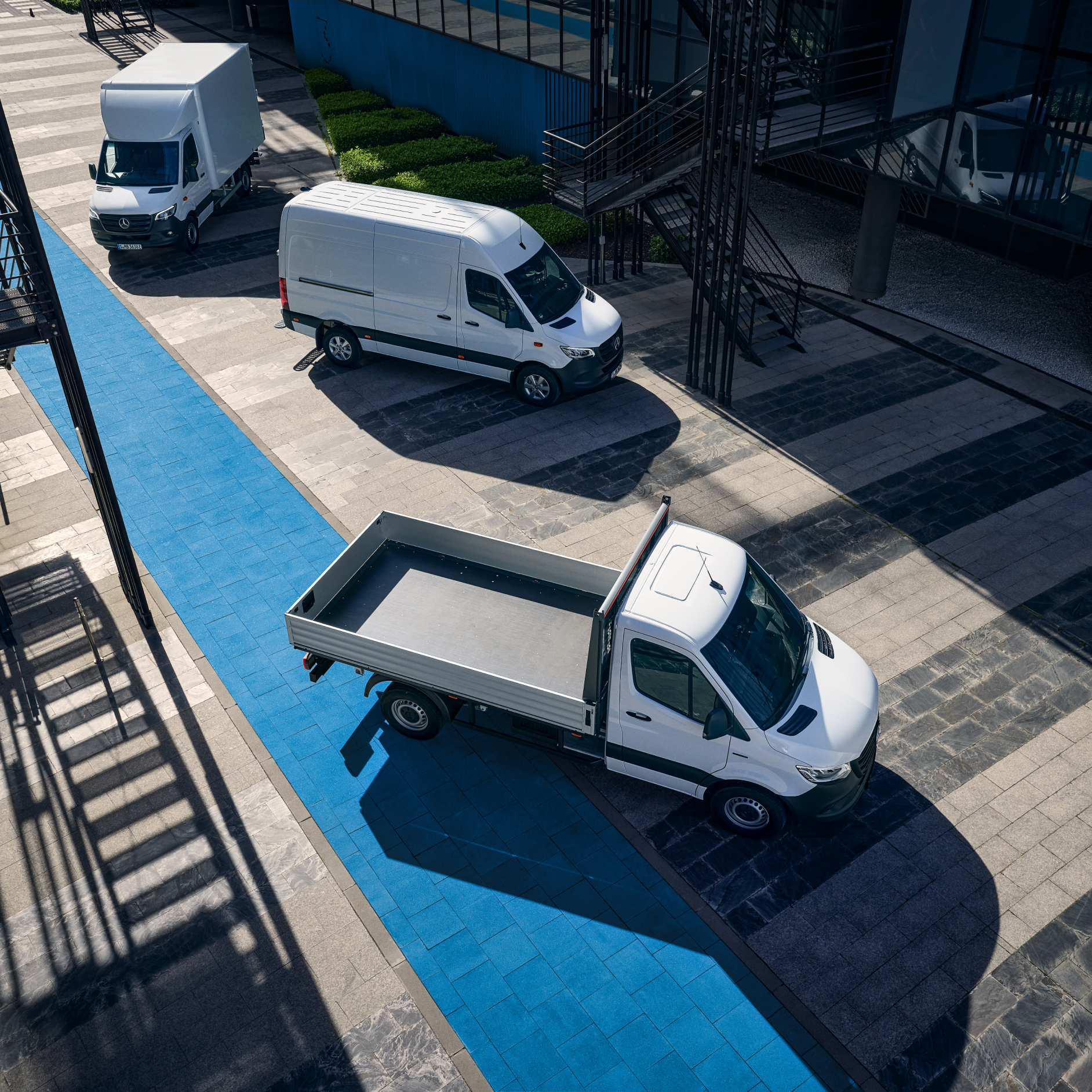 Alléns Gård | Mercedes-Benz Transportbilar Tre vita Mercedes-Benz eSprinter står parkerade vid laddstolpe