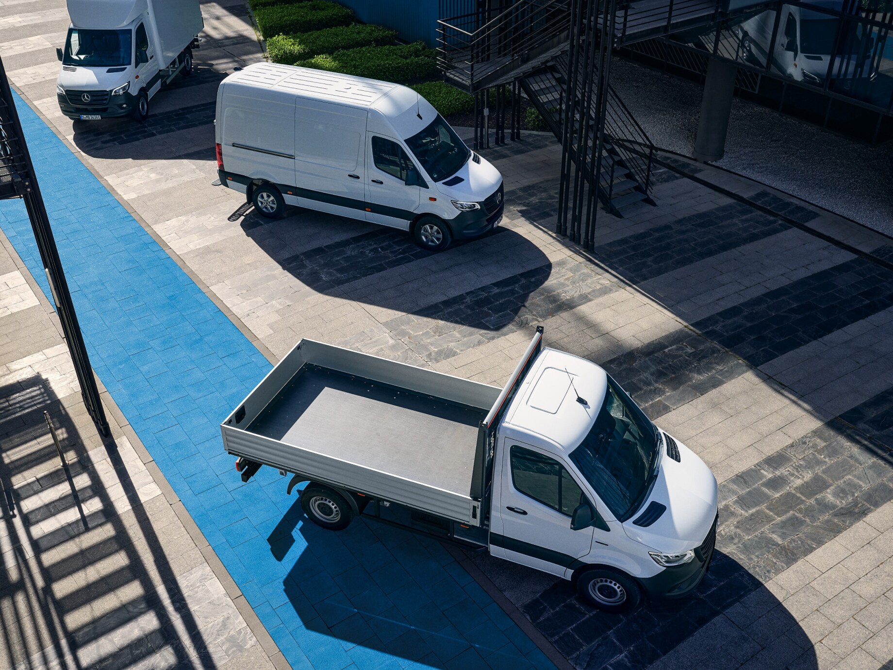 Tre vita Mercedes-Benz eSprinter som laddas