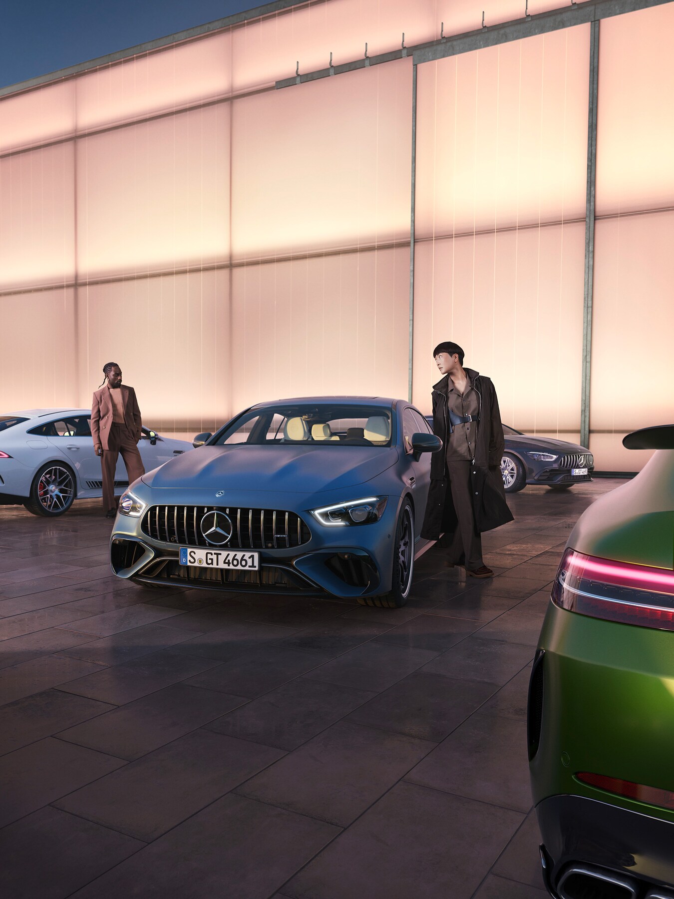 Två personer omgivna av olika Mercedes-AMG-modeller