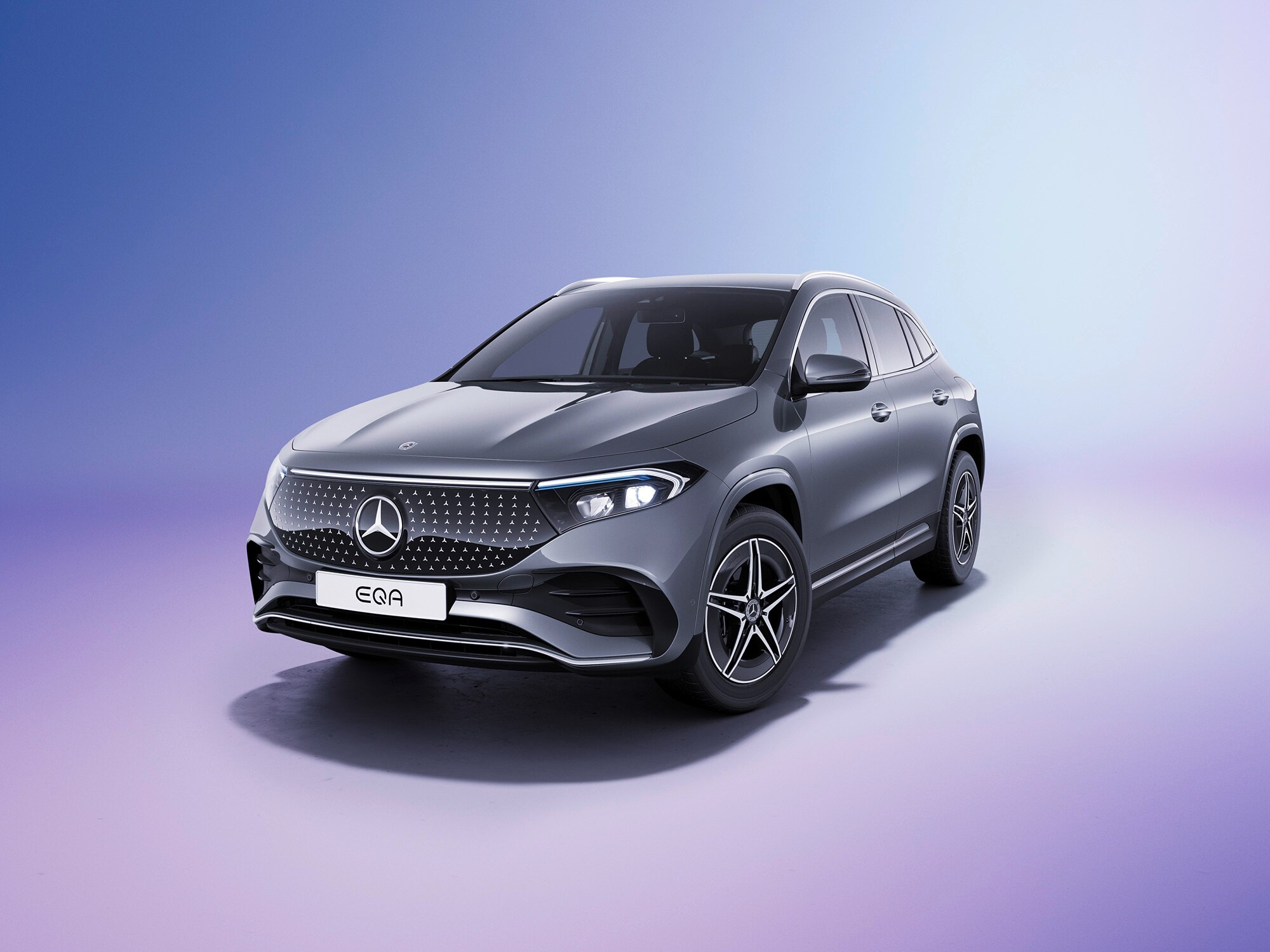En grå Mercedes-Benz EQA SUV sedd från sidan mot färgglad bakgrund.