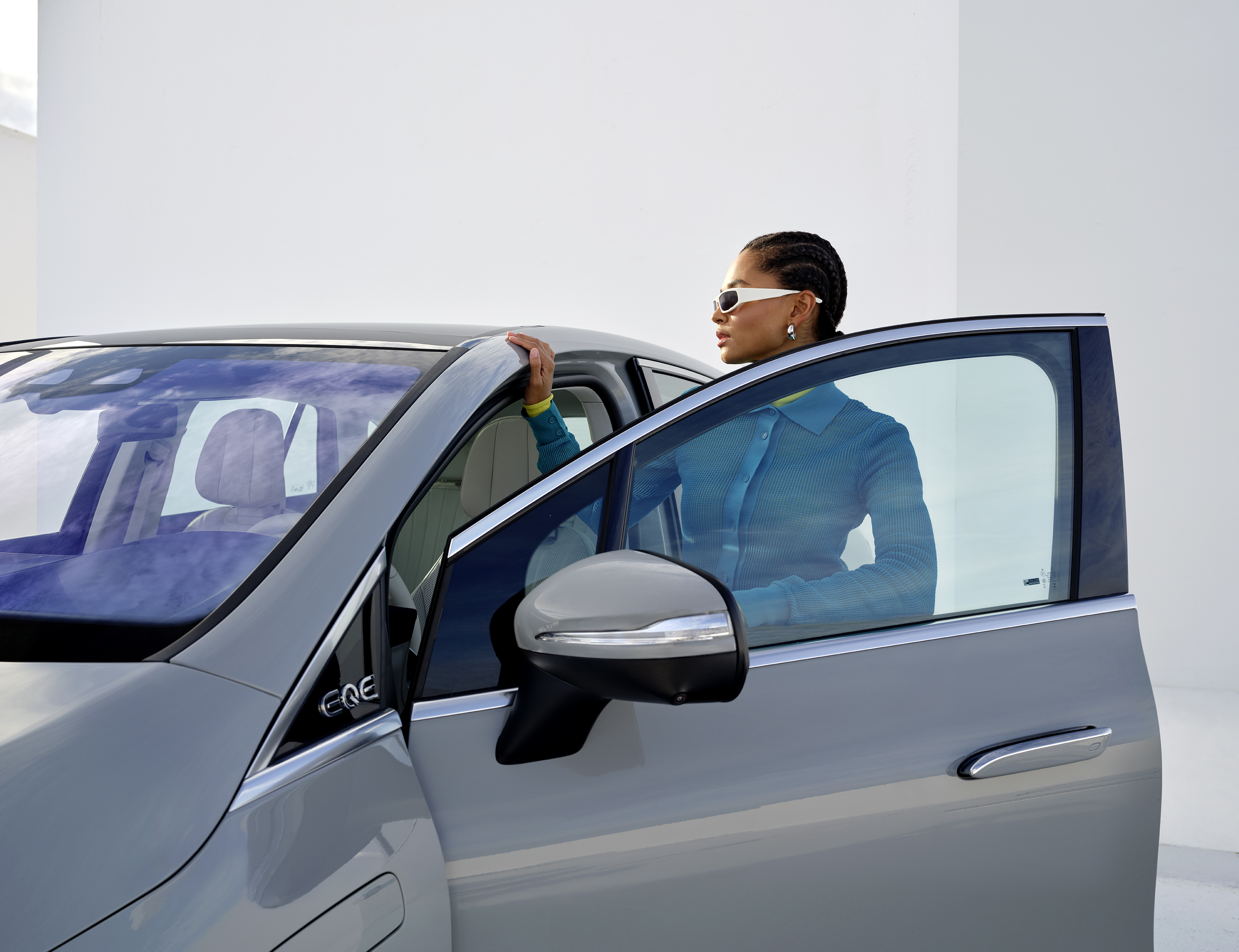 Leasa en begagnad elbil | Leasa en elbil | Mercedes-Benz Kvinde står ved siden af sin Mercedes-Benz EQE