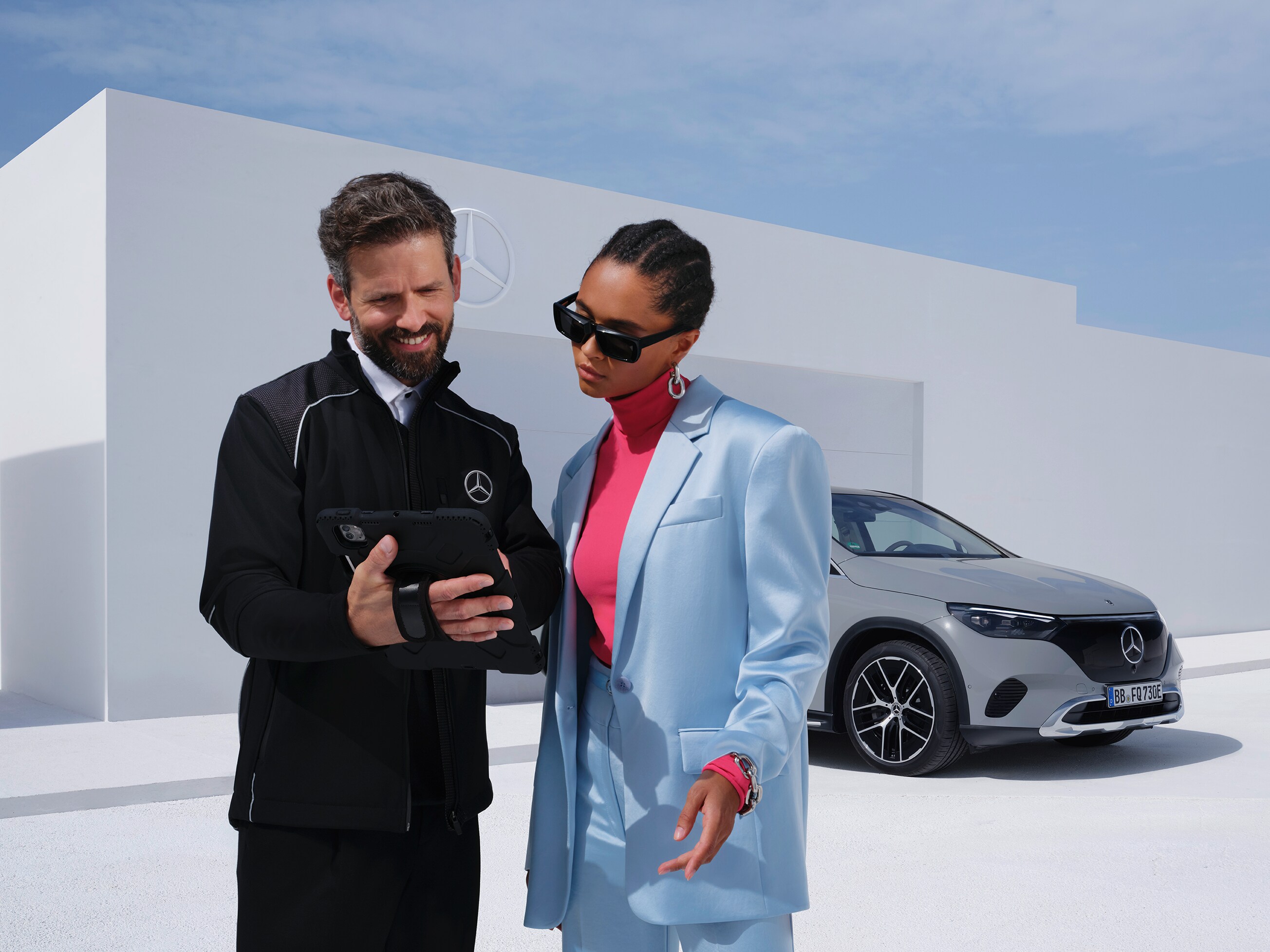 Kvinna pratar med en Mercedes-Benz-anställd om att leasa en elektrisk tjänstebil