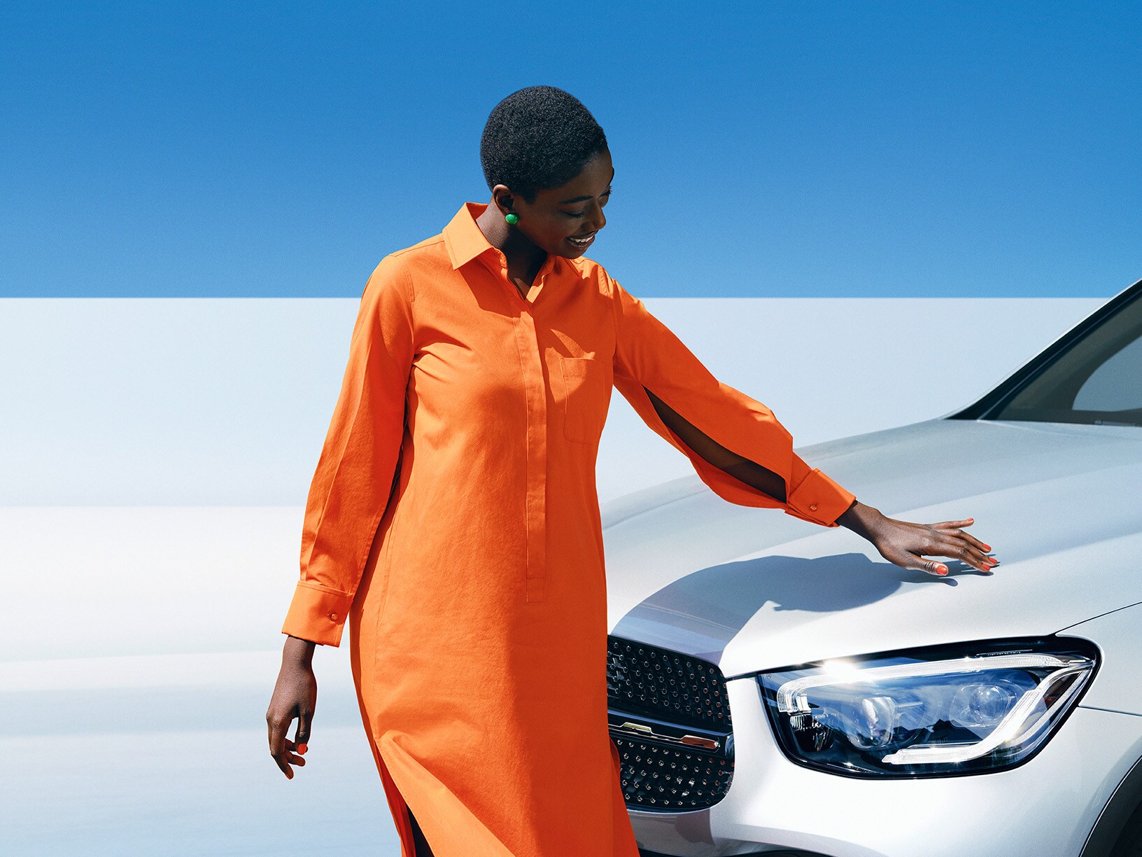 Kvinna beundrar lacken på sin vita SUV från Mercedes-Benz