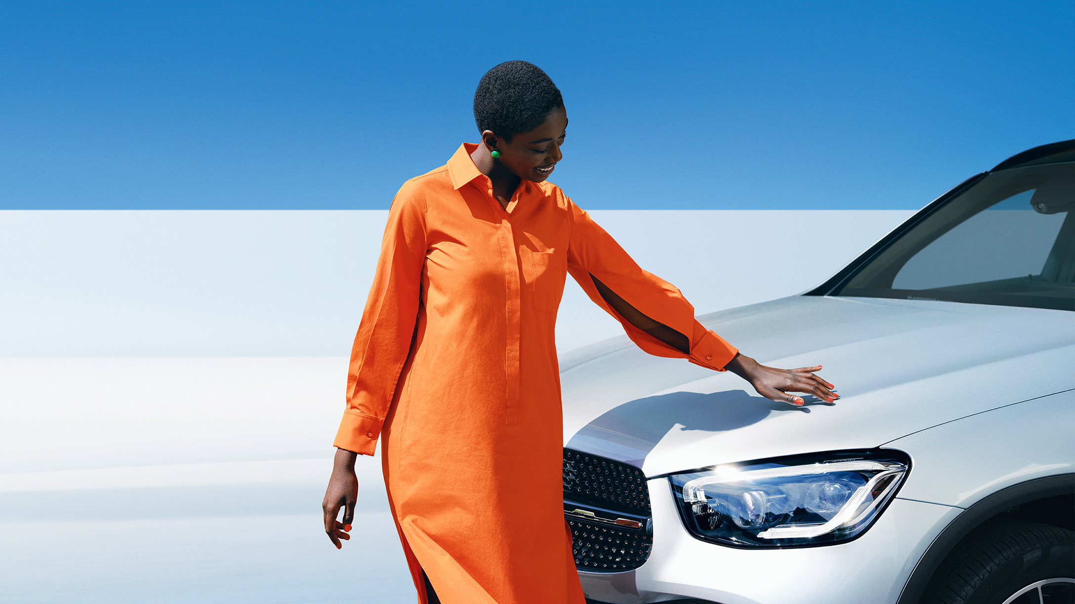 Laddhybrid SUV | Mercedes-Benz Kvinna beundrar lacken på sin vita SUV från Mercedes-Benz