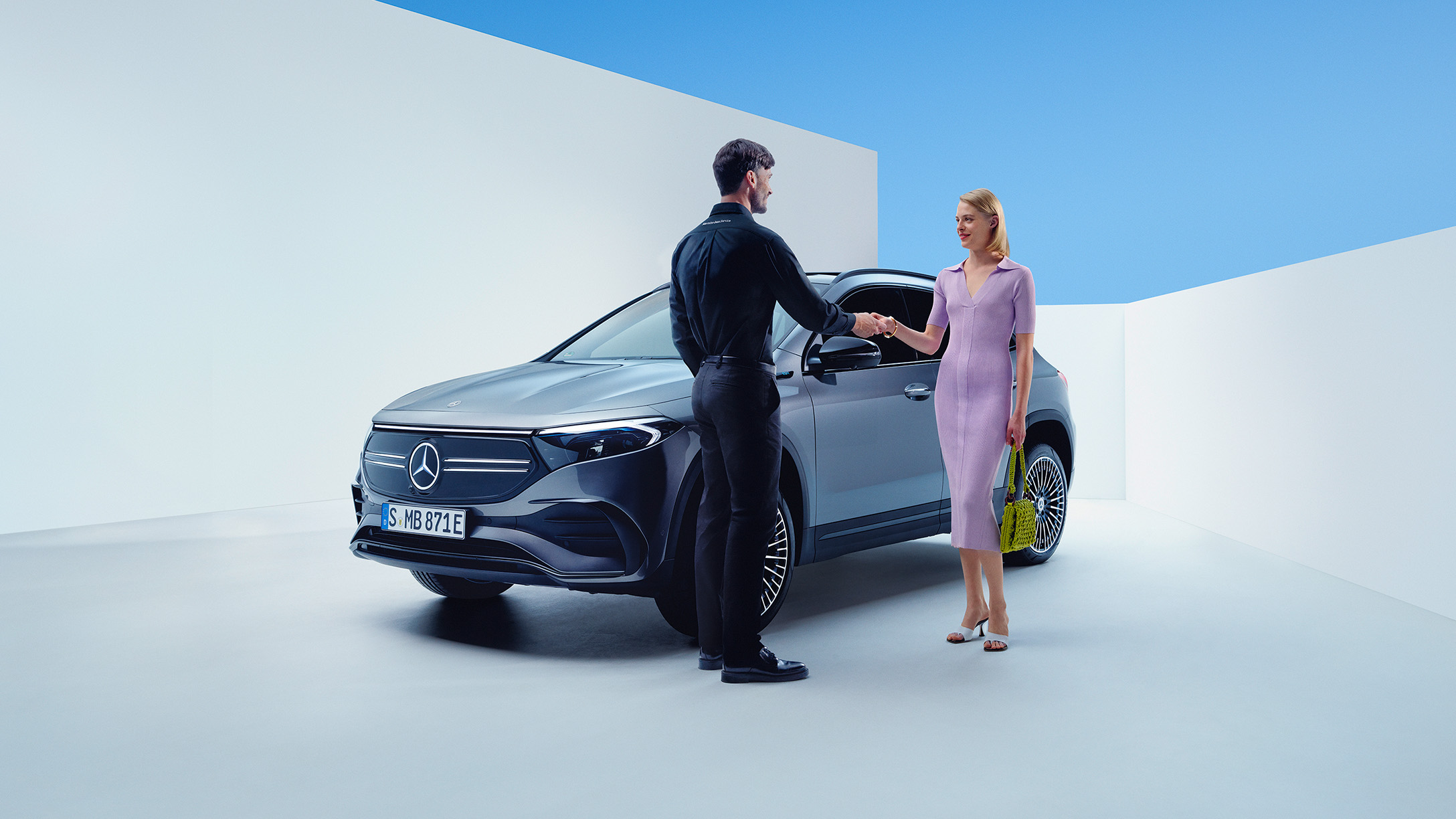 Laddhybrid SUV | Mercedes-Benz Kvinna tar emot bilnycklar från en Mercedes-Benz servicemedarbetare