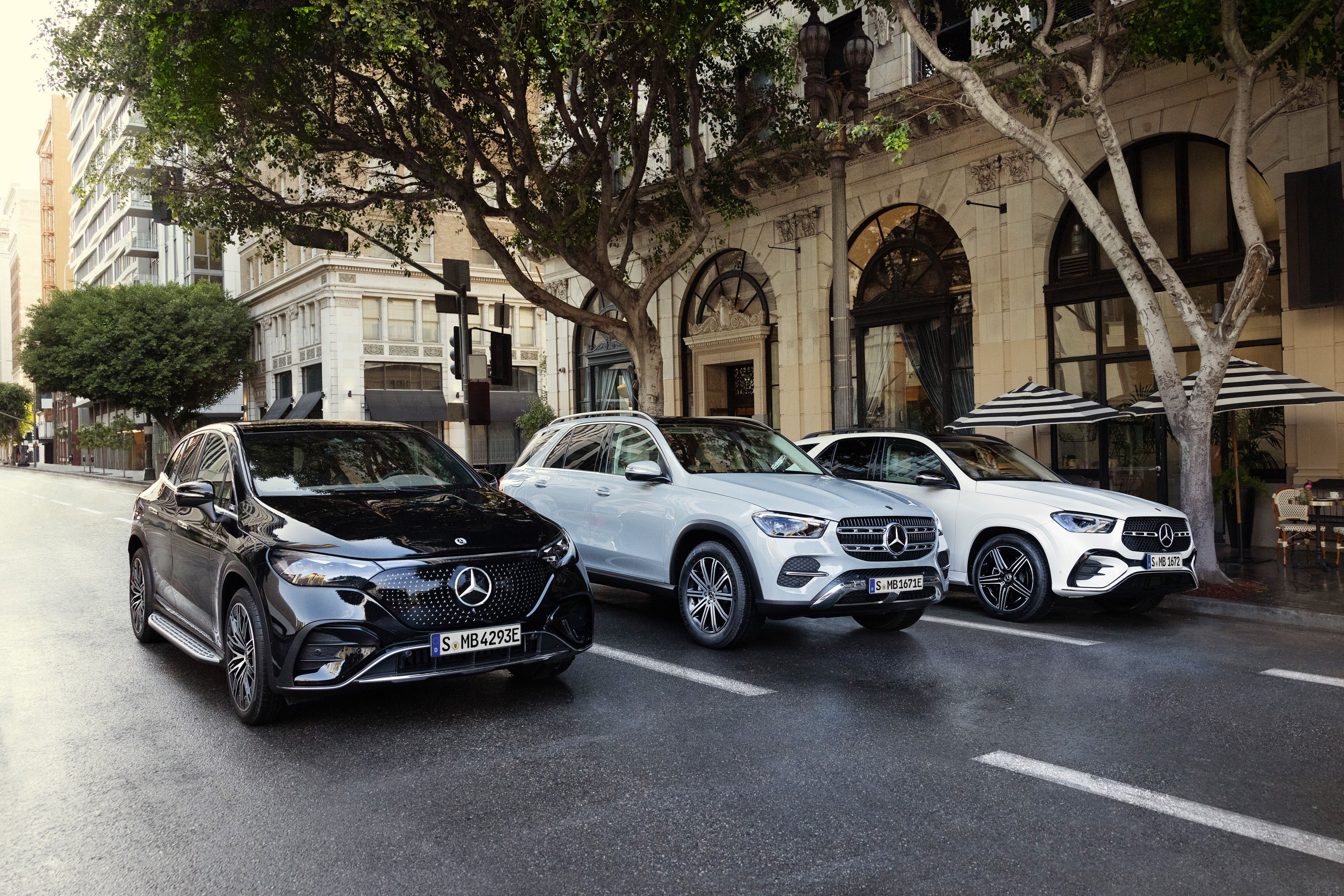 Vilken bil passar dig | Mercedes-Benz Tre olika Mercedes-Benz modeller sida vid sida på en väg i storstad.