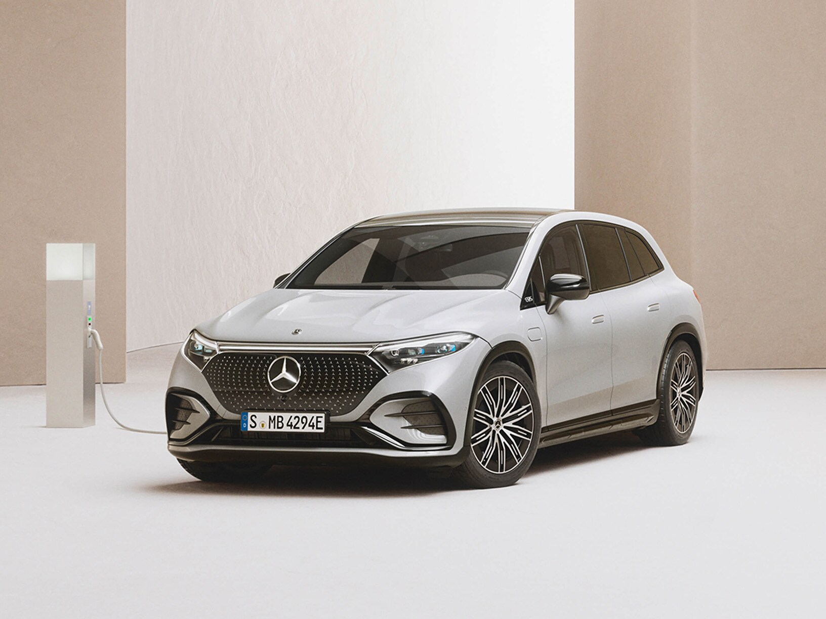 Mercedes-Benz SUV laddar vid laddstation i ett minimalistiskt showroom