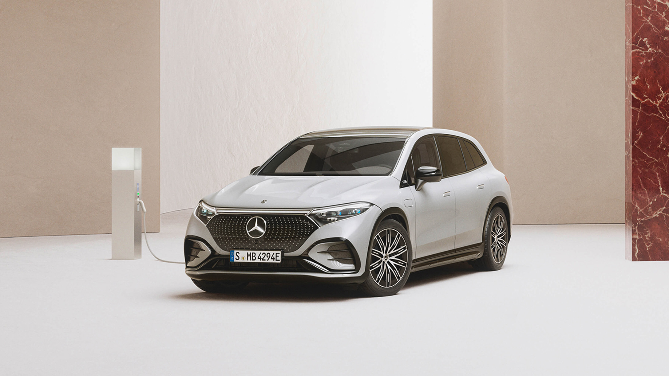 Elbilar SUV | Mercedes-Benz Mercedes-Benz SUV laddar vid laddstation i ett minimalistiskt showroom