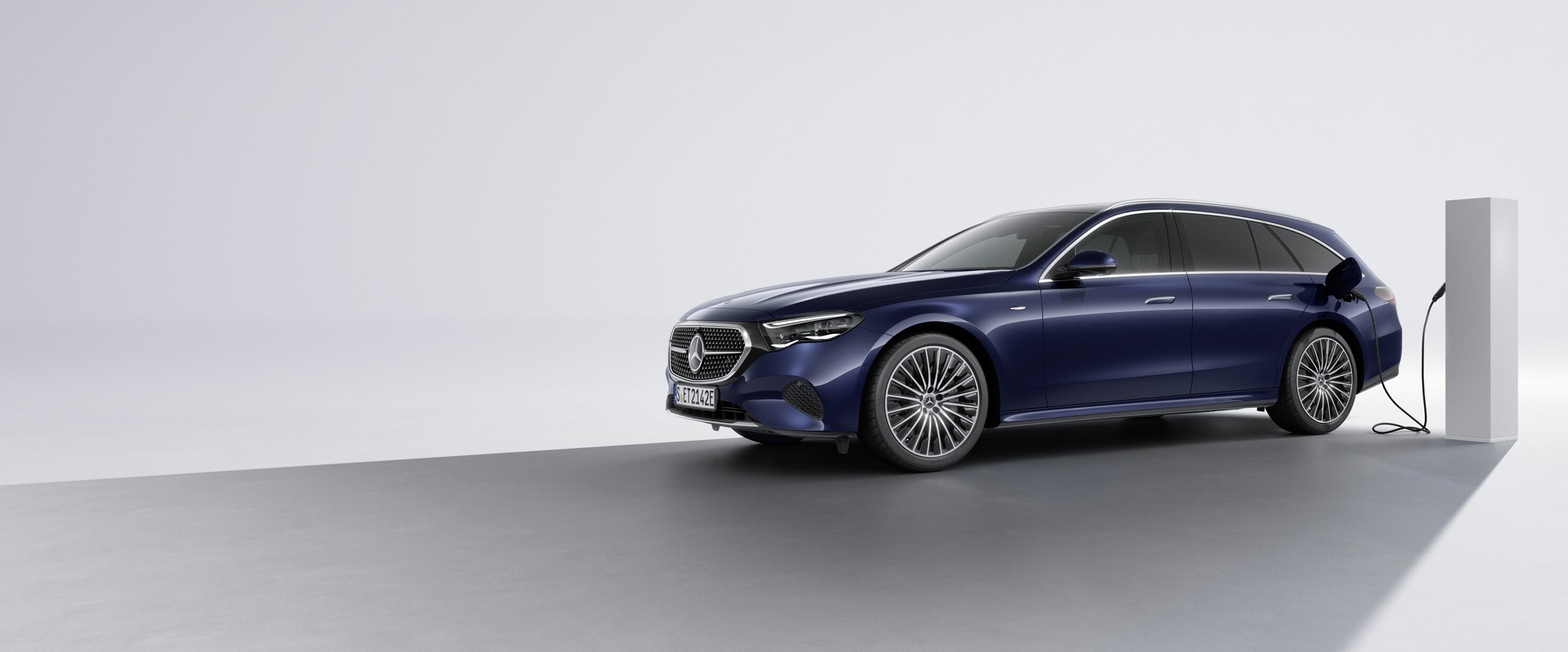 En laddhybridbil från Mercedes-Benz sedd bakifrån vid en laddningsstation.