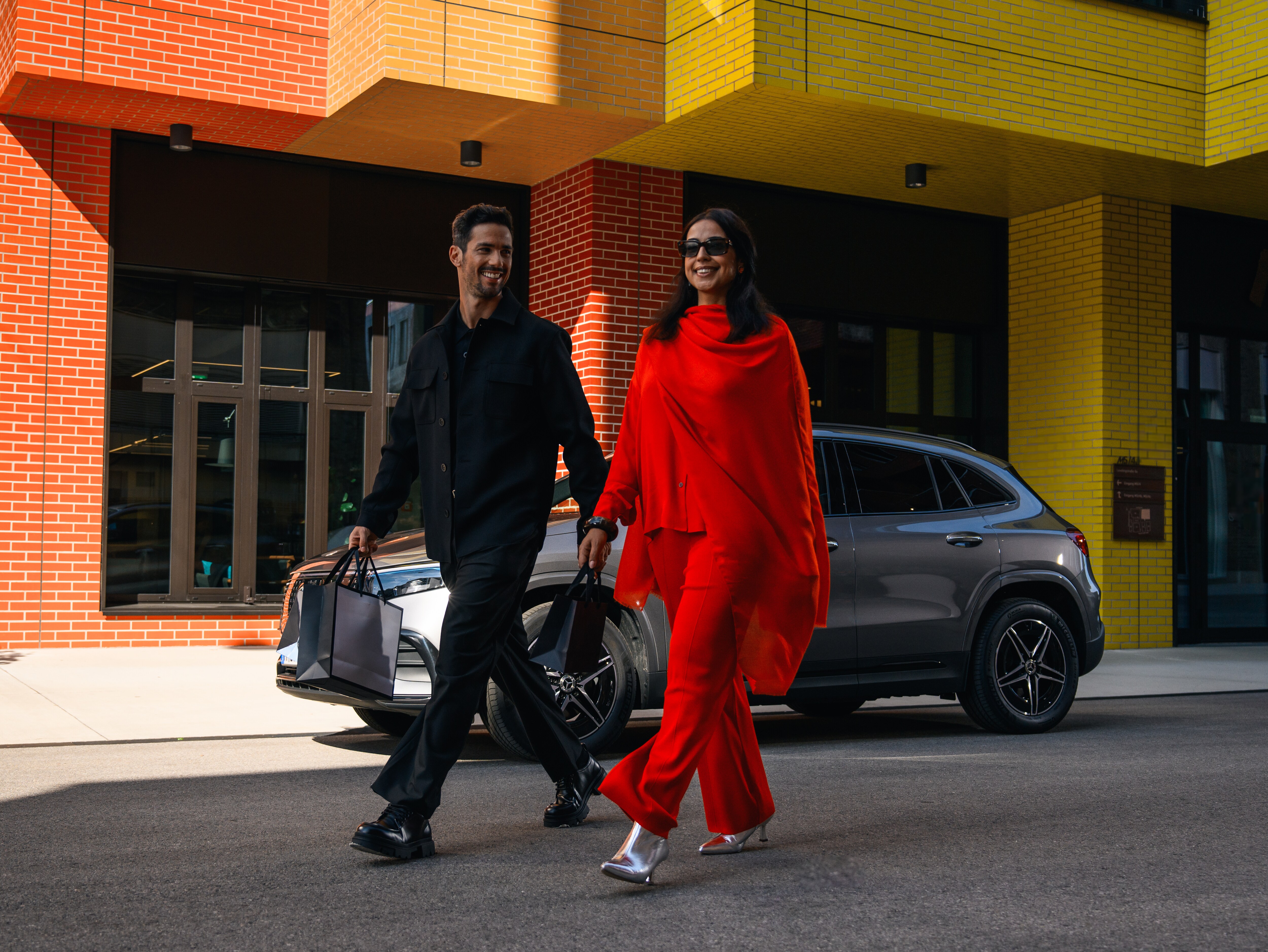 Man och kvinna framför en parkerad Mercedes-Benz.