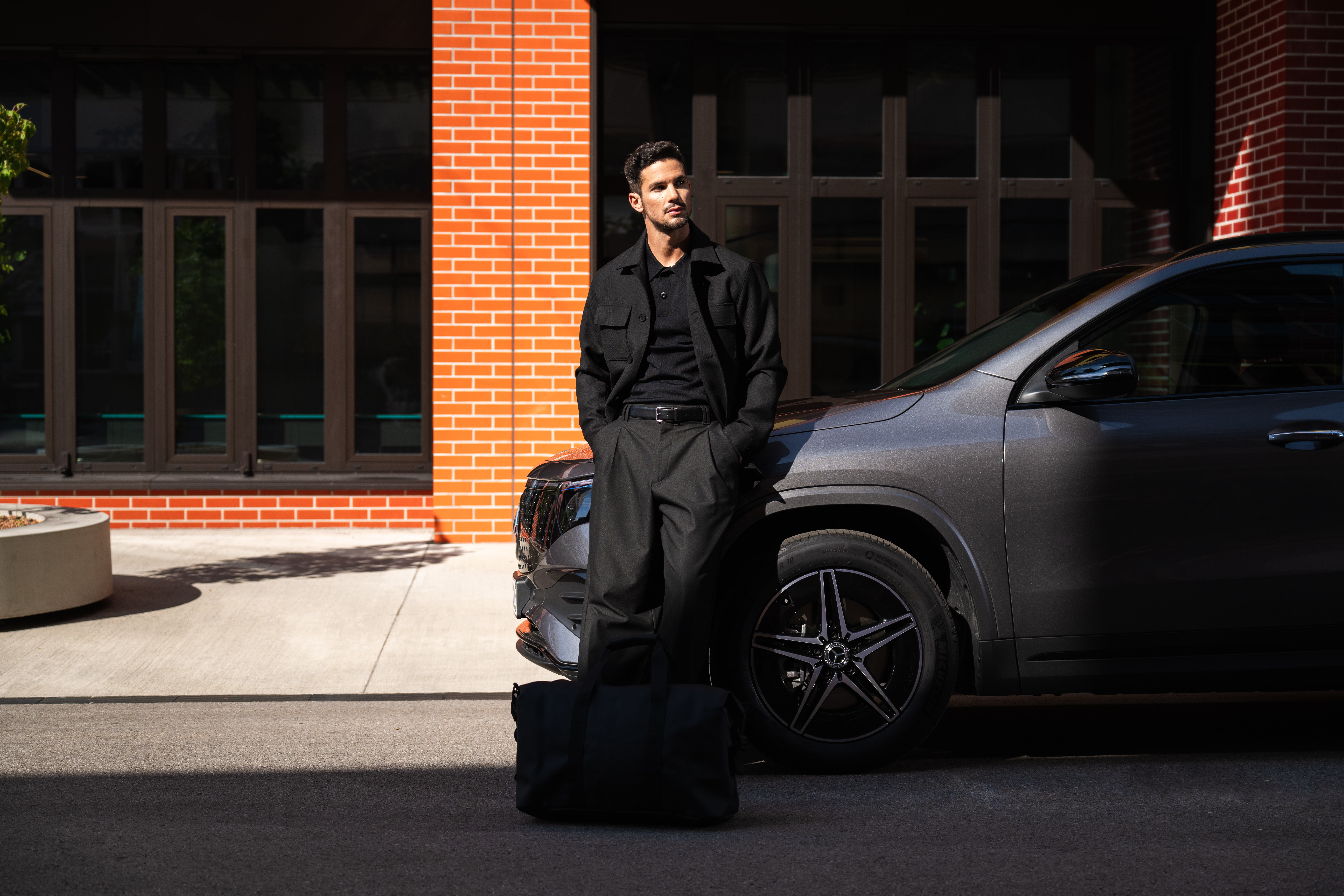 BusinessLeasing | Aktuella erbjudanden och kampanjer | Mercedes-Benz Man lutar sig mot sin Mercedes-Benz.