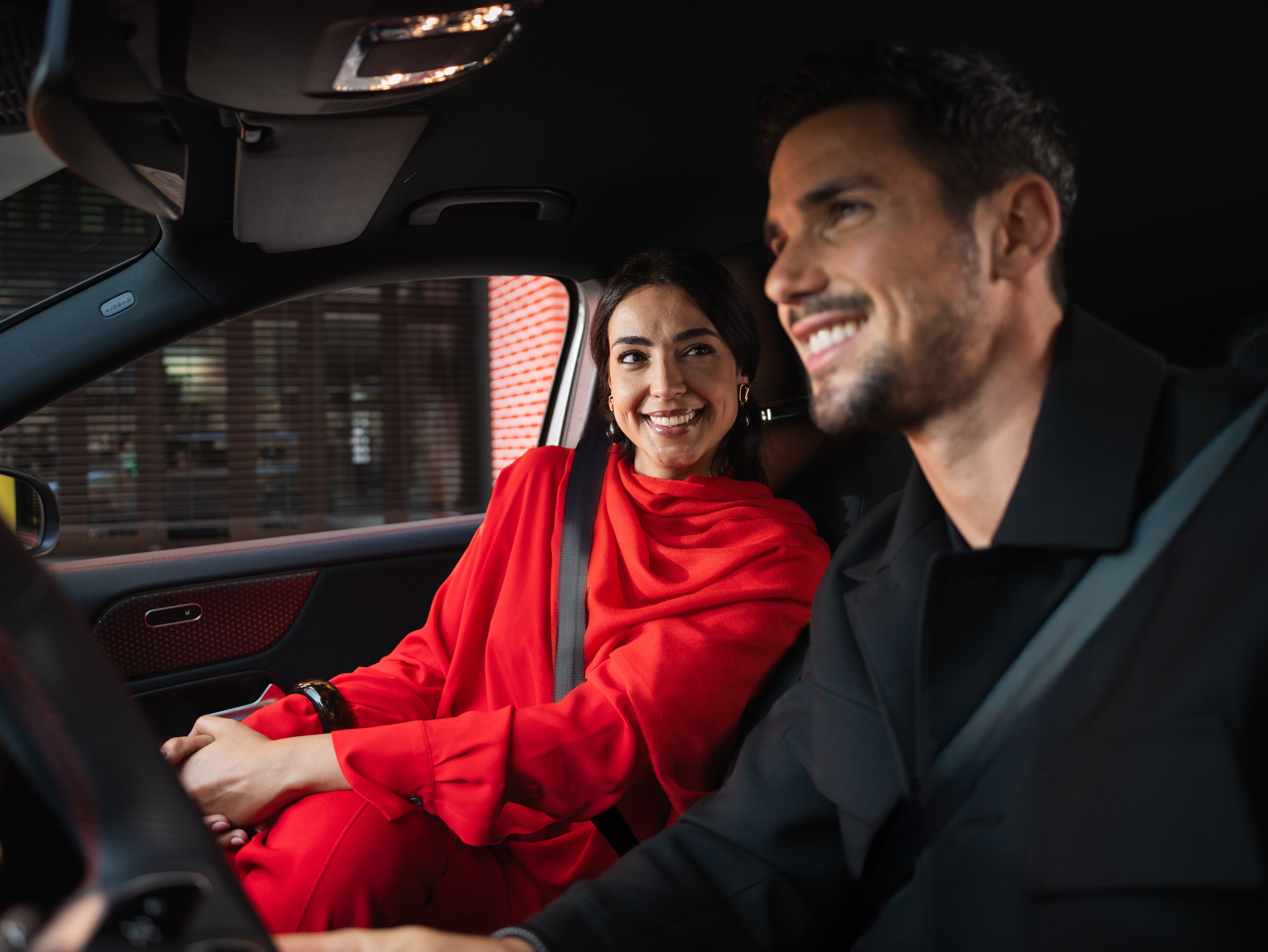 Man och kvinna kör en Mercedes-Benz.