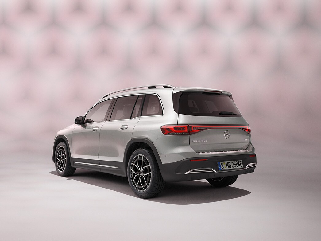 En silvrig Mercedes-Benz EQB SUV sedd bakifrån mot färgglad bakgrund.