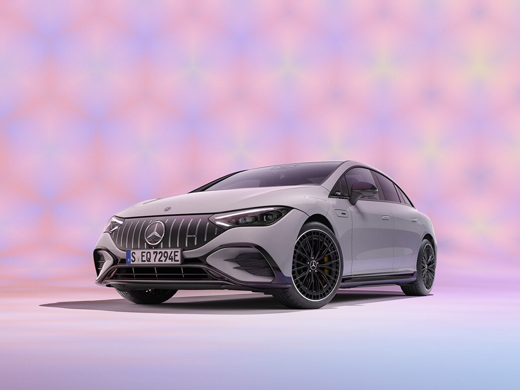 En grå Mercedes-Benz EQE Sedan sedd från framsidan mot färgglad bakgrund.