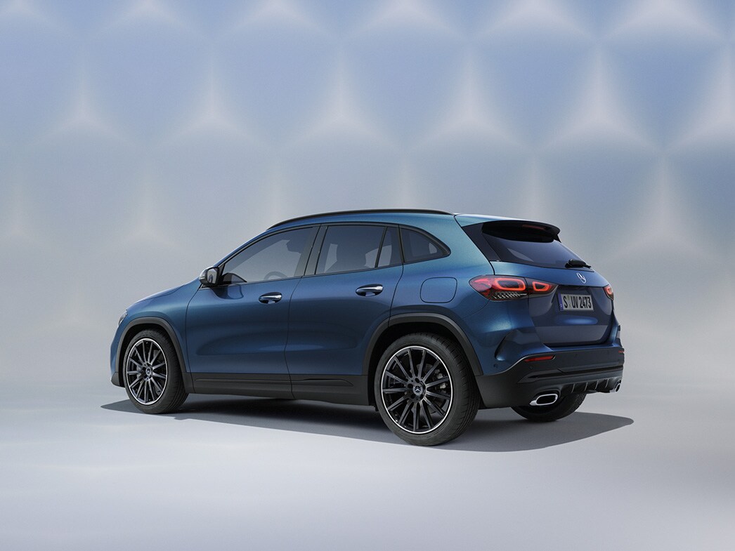 En blå Mercedes-Benz GLA SUV sedd bakifrån mot färgglad bakgrund.