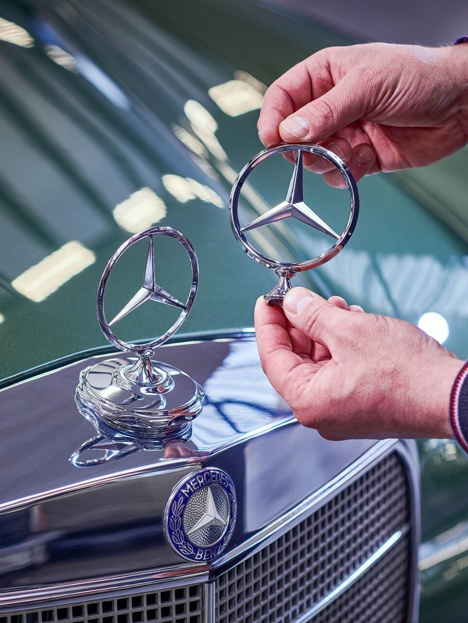 En man jämför Mercedes-stjärnor på en klassisk Mercedes-Benz.