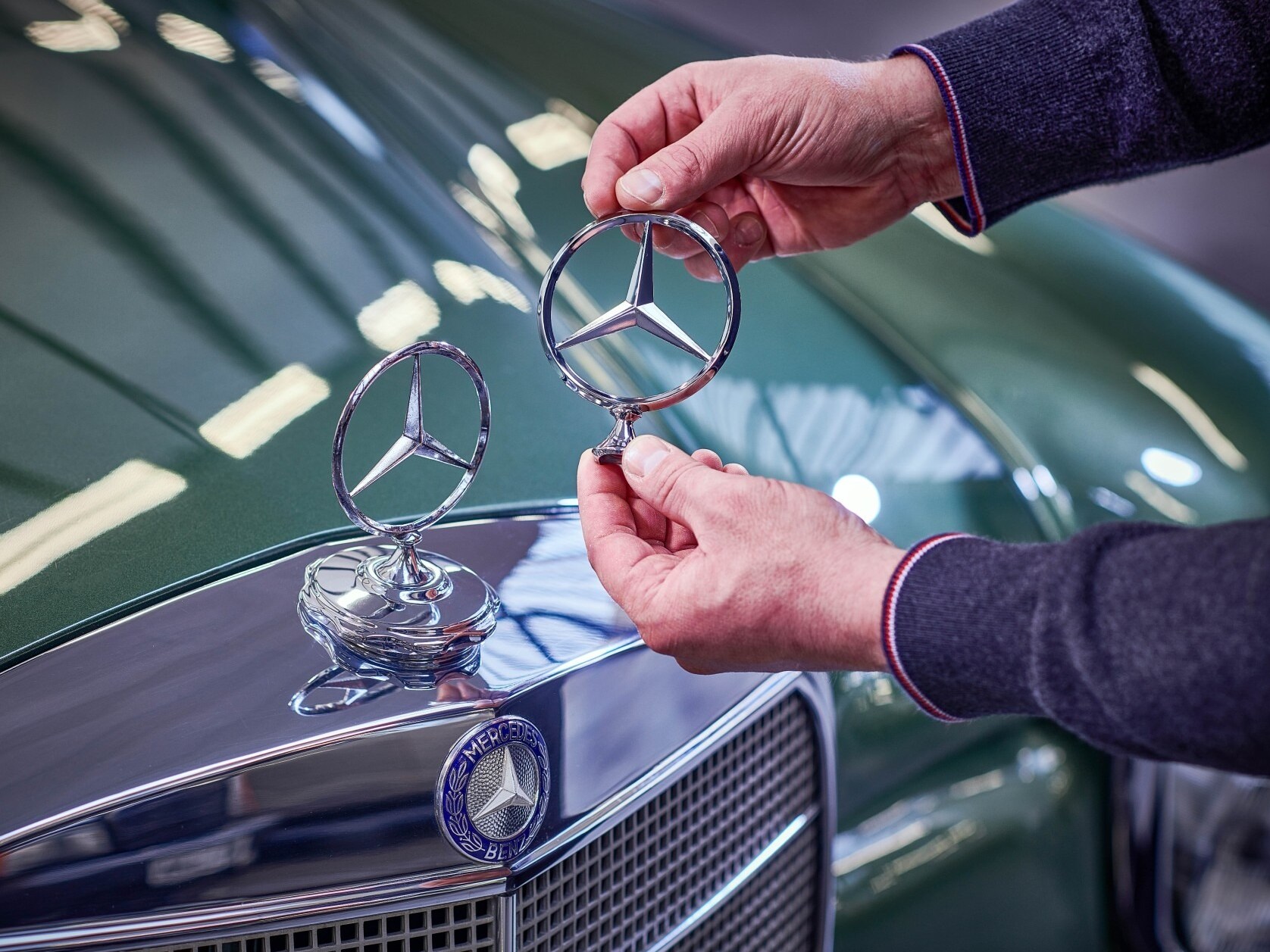 En man jämför Mercedes-stjärnor på en klassisk Mercedes-Benz.