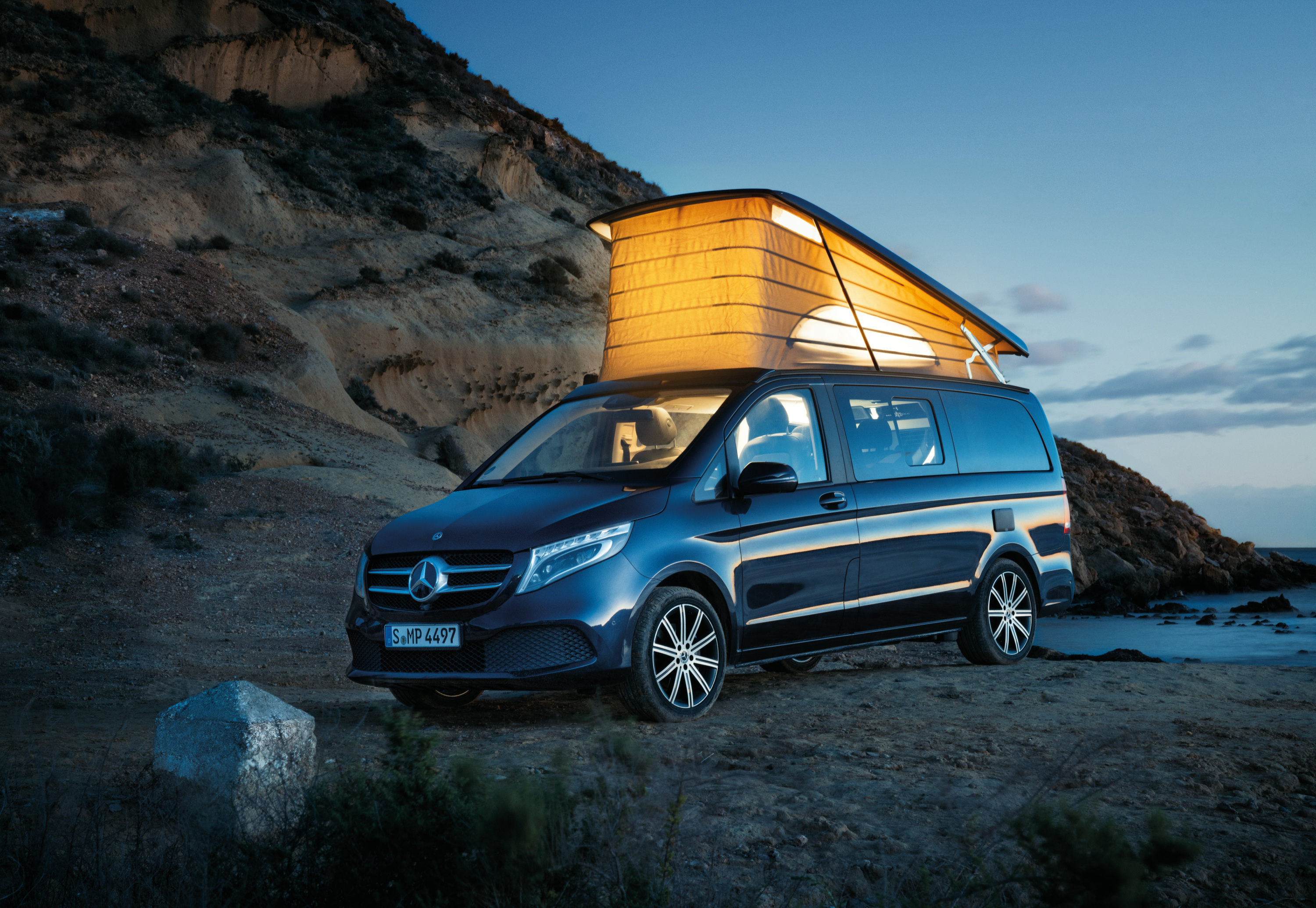 Campingbil | Sprinter husbilar & plåtisar | Mercedes-Benz Transportbilar Mercedes-Benz Marco Polo parkerad vid sjö med utfällt pop-up tak