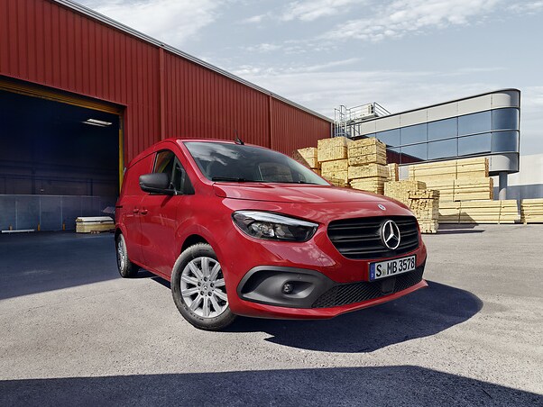 Röd Mercedes-Benz Citan skåpbil framför lagerbyggnad