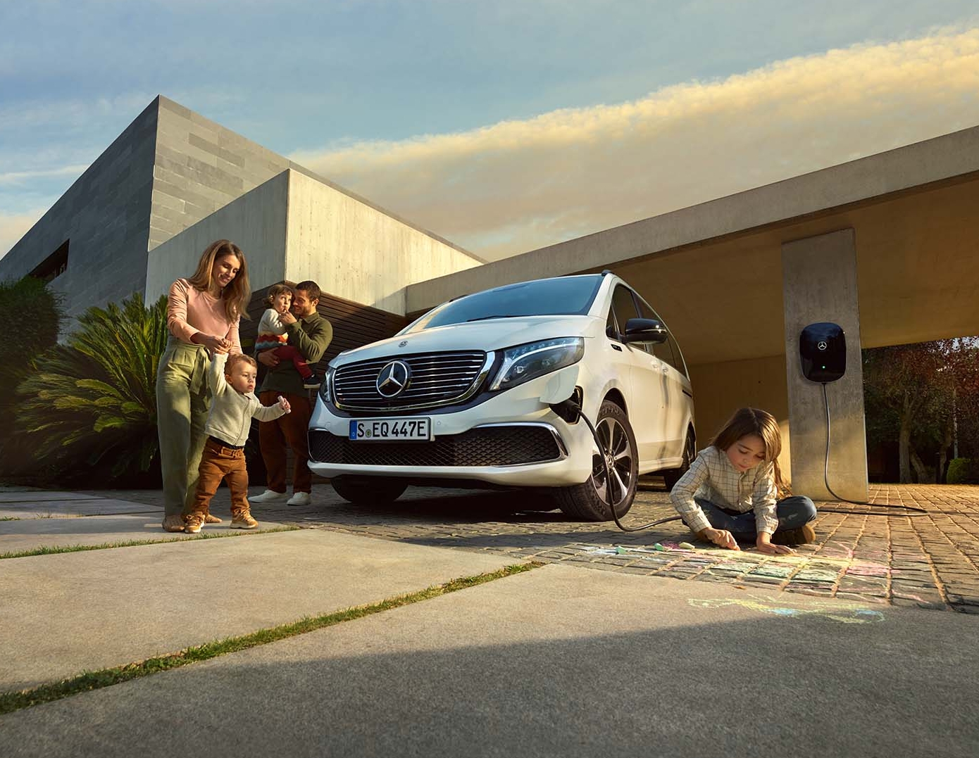 Vad säger våra kunder | Familjebill | Mercedes-Benz Familj i uppfarten vid sitt hus med sin elektriska Mercedes-Benz familjebil.