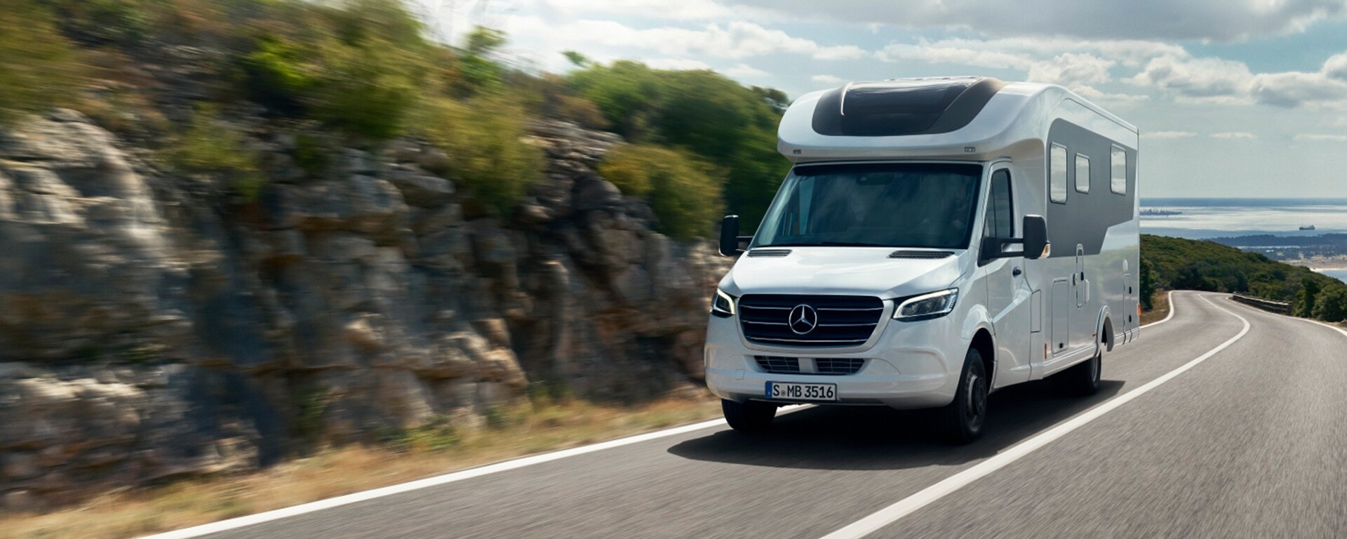 Husbil | Familjebill | Mercedes-Benz Vit husbil från Mercedes-Benz kör uppför en bergsväg